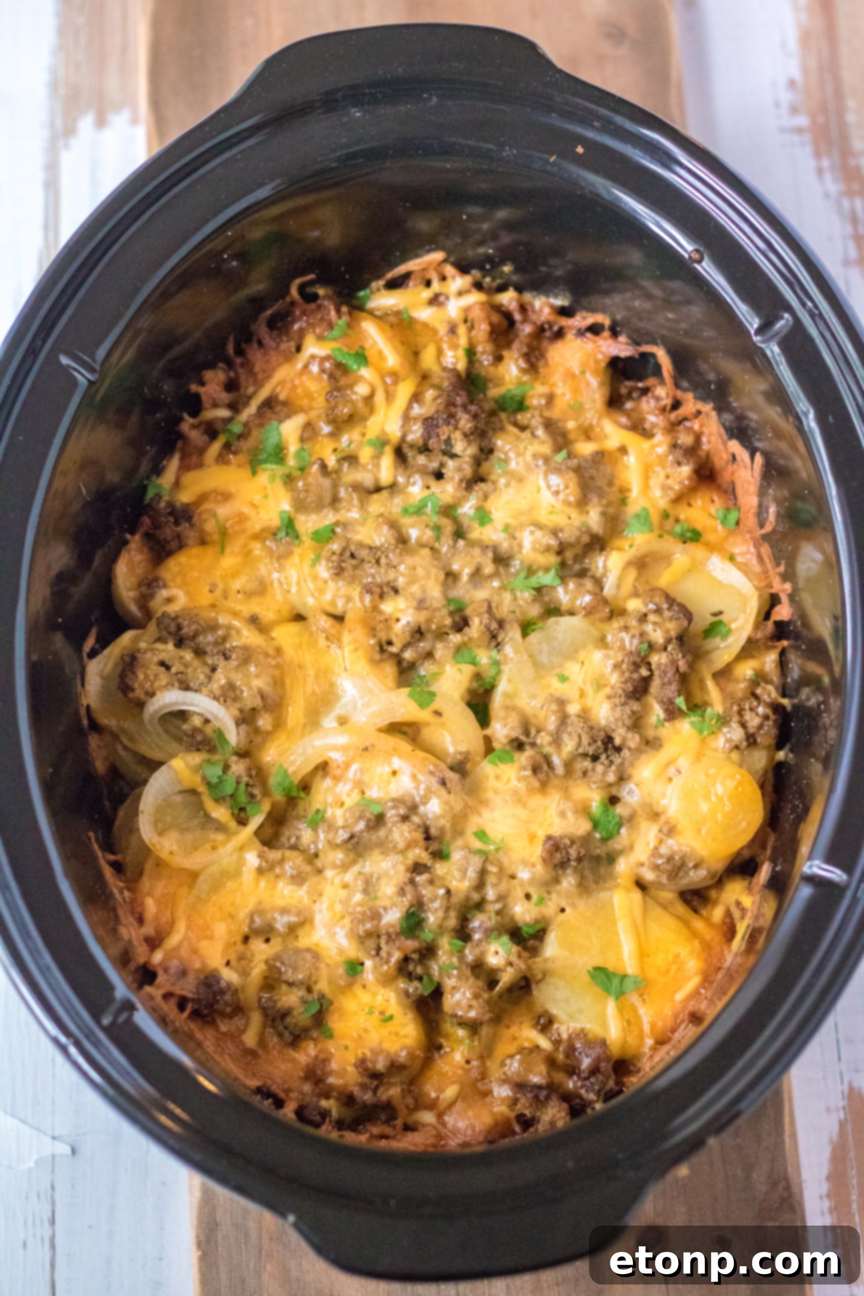 Raw ingredients for Slow Cooker Beef and Potato Au Gratin, including sliced potatoes, browned ground beef, onions, and cheese, laid out before cooking.