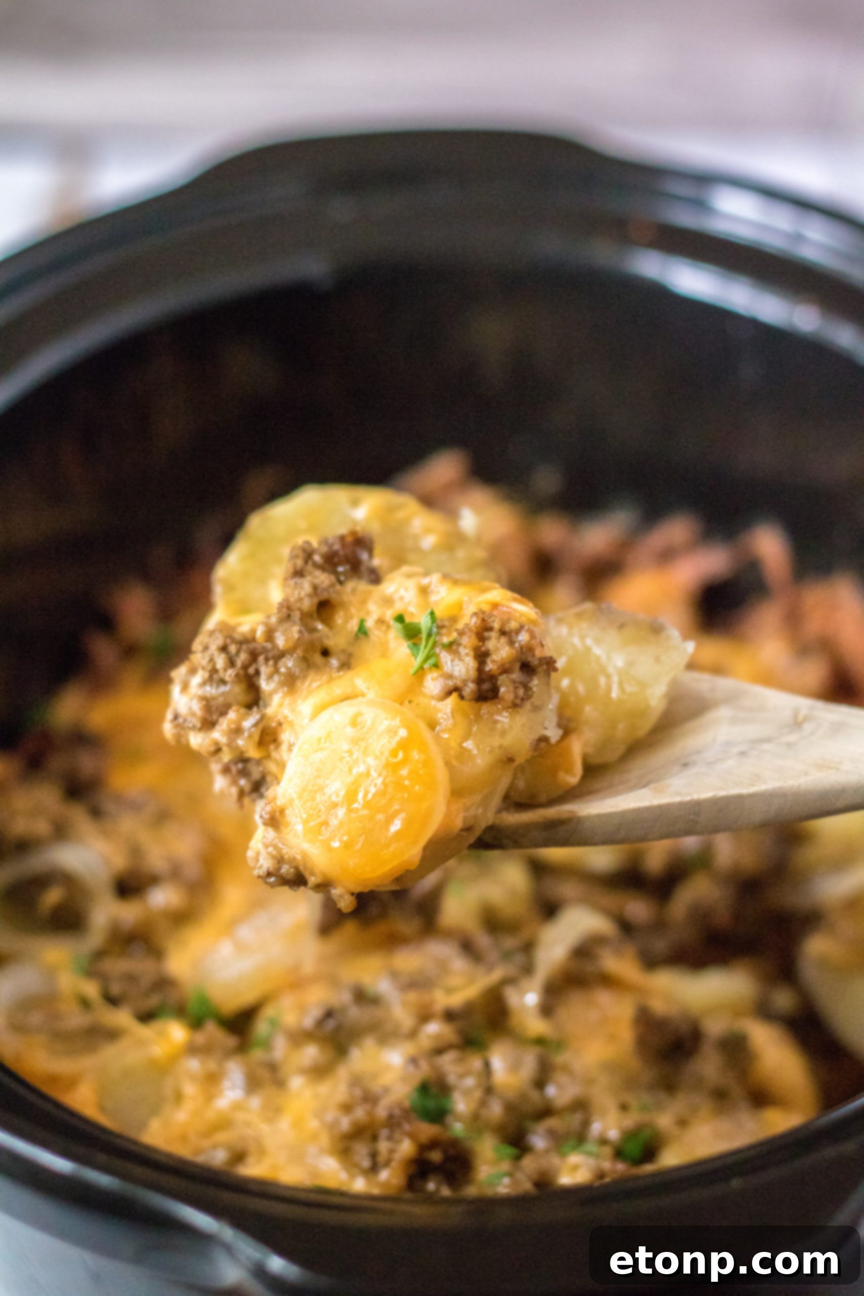 Freshly cooked Slow Cooker Beef and Potato Au Gratin, still in the slow cooker, steaming and ready to be served.