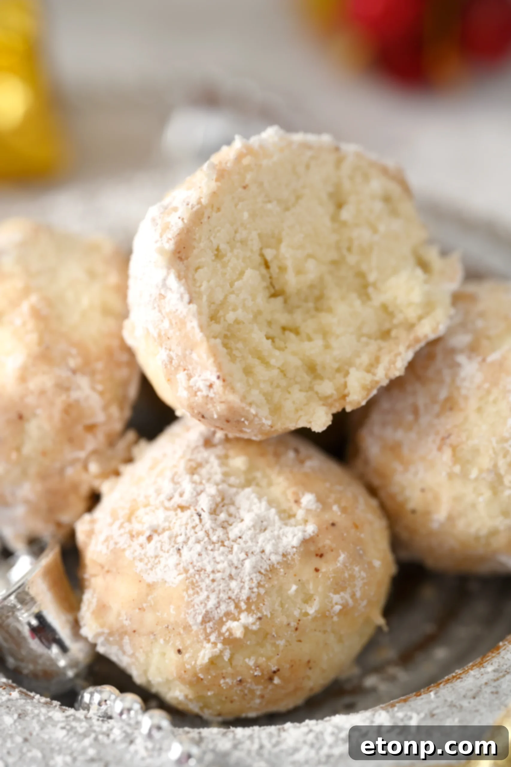 Cinnamon Mexican Wedding Cookies presented on a clean white surface, showcasing their pristine appearance and delightful texture after being coated.