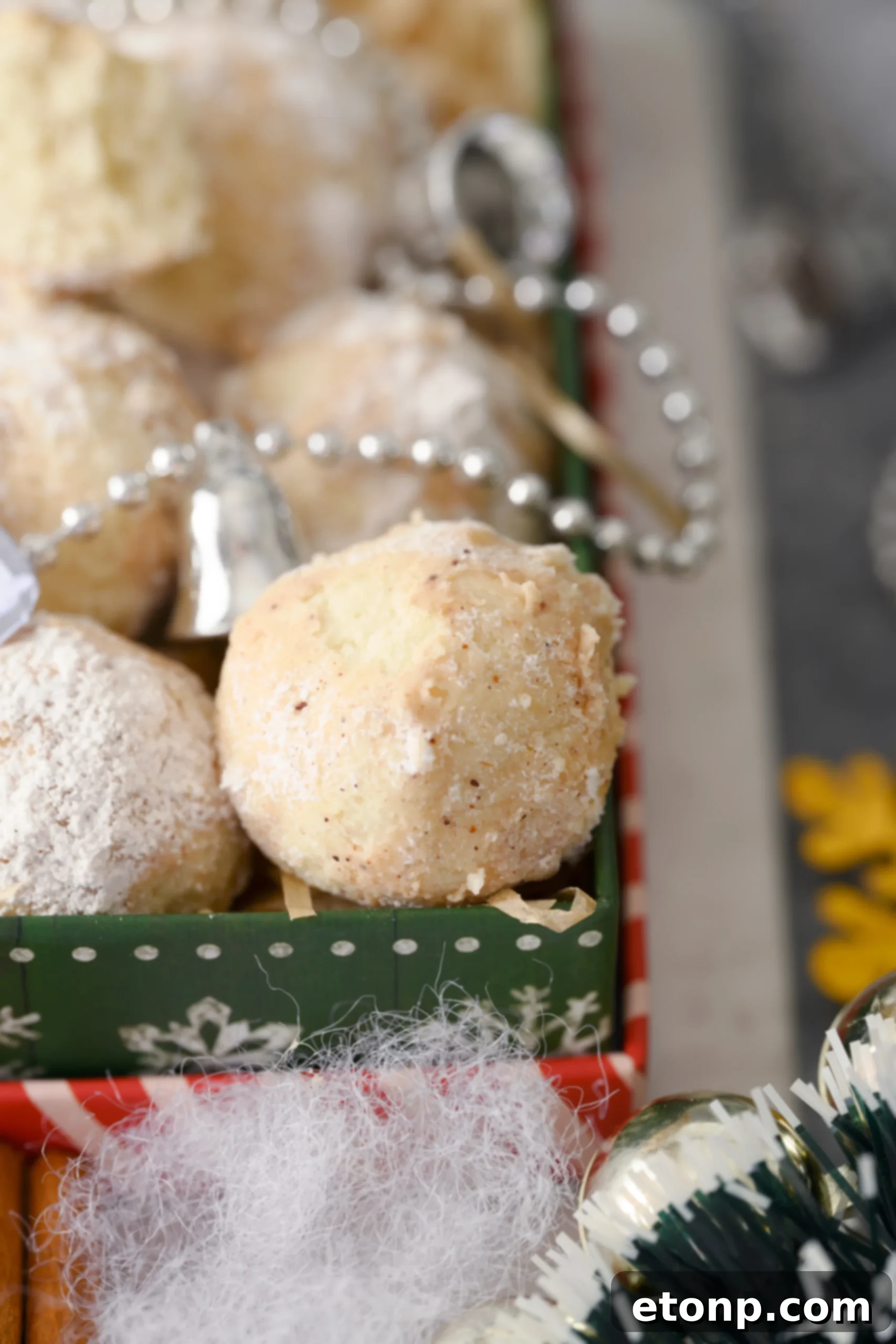 A pair of Cinnamon Mexican Wedding Cookies resting on a white napkin, perfectly showcasing their dusted surfaces and inviting texture.