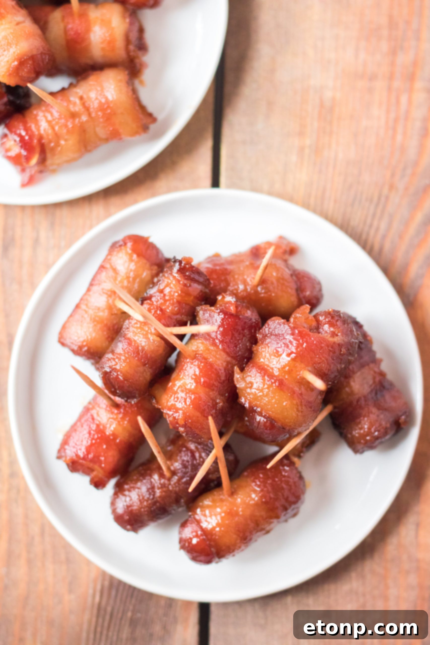 Crock-Pot Candy Bacon Smokies 11 A serving platter overflowing with cooked Slow Cooker Bacon Wrapped Smokies, garnished with fresh parsley.