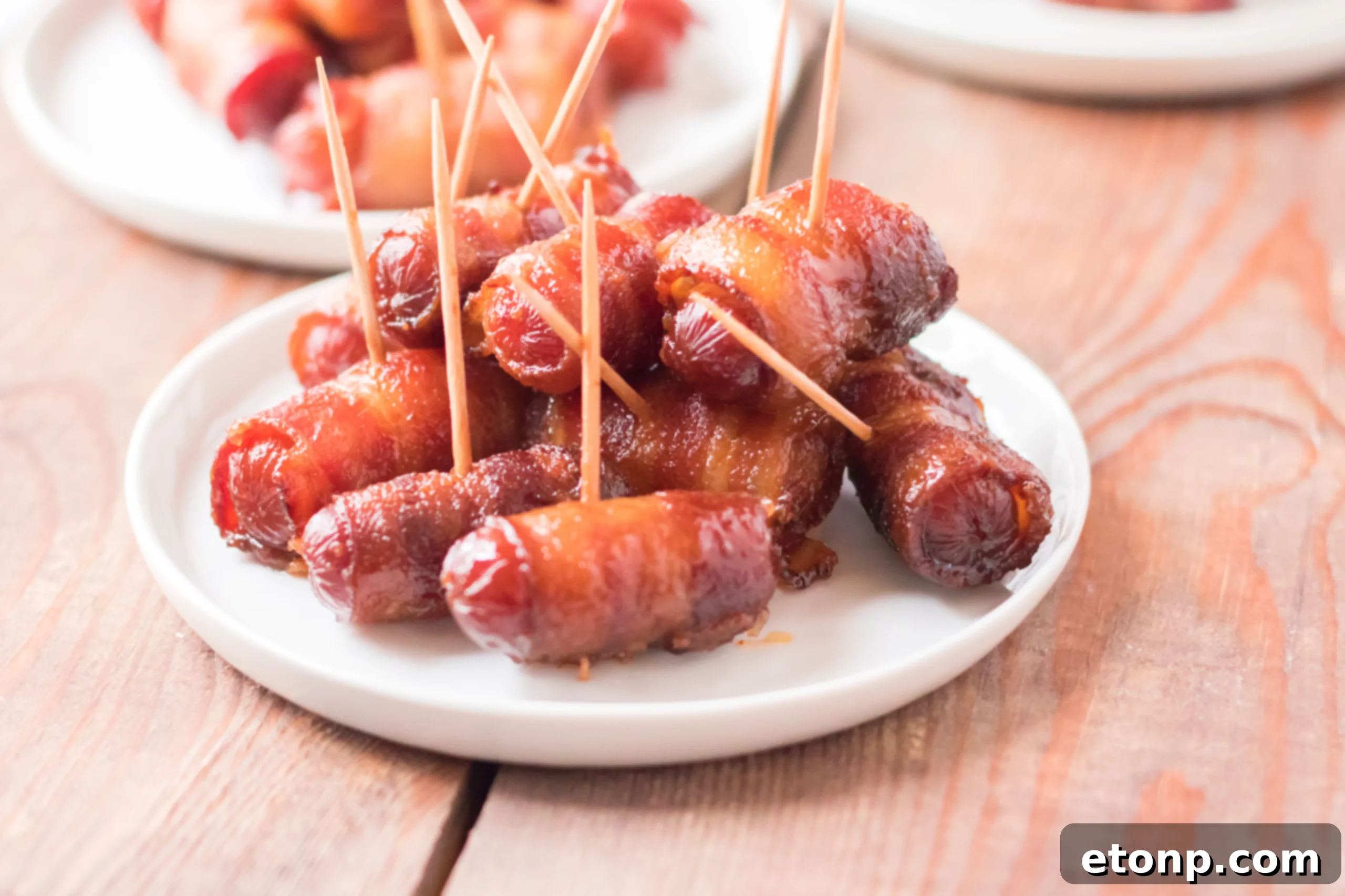 Crock-Pot Candy Bacon Smokies 6 A close-up of a single Slow Cooker Bacon Wrapped Smokie, showcasing the crispy bacon and caramelized brown sugar.