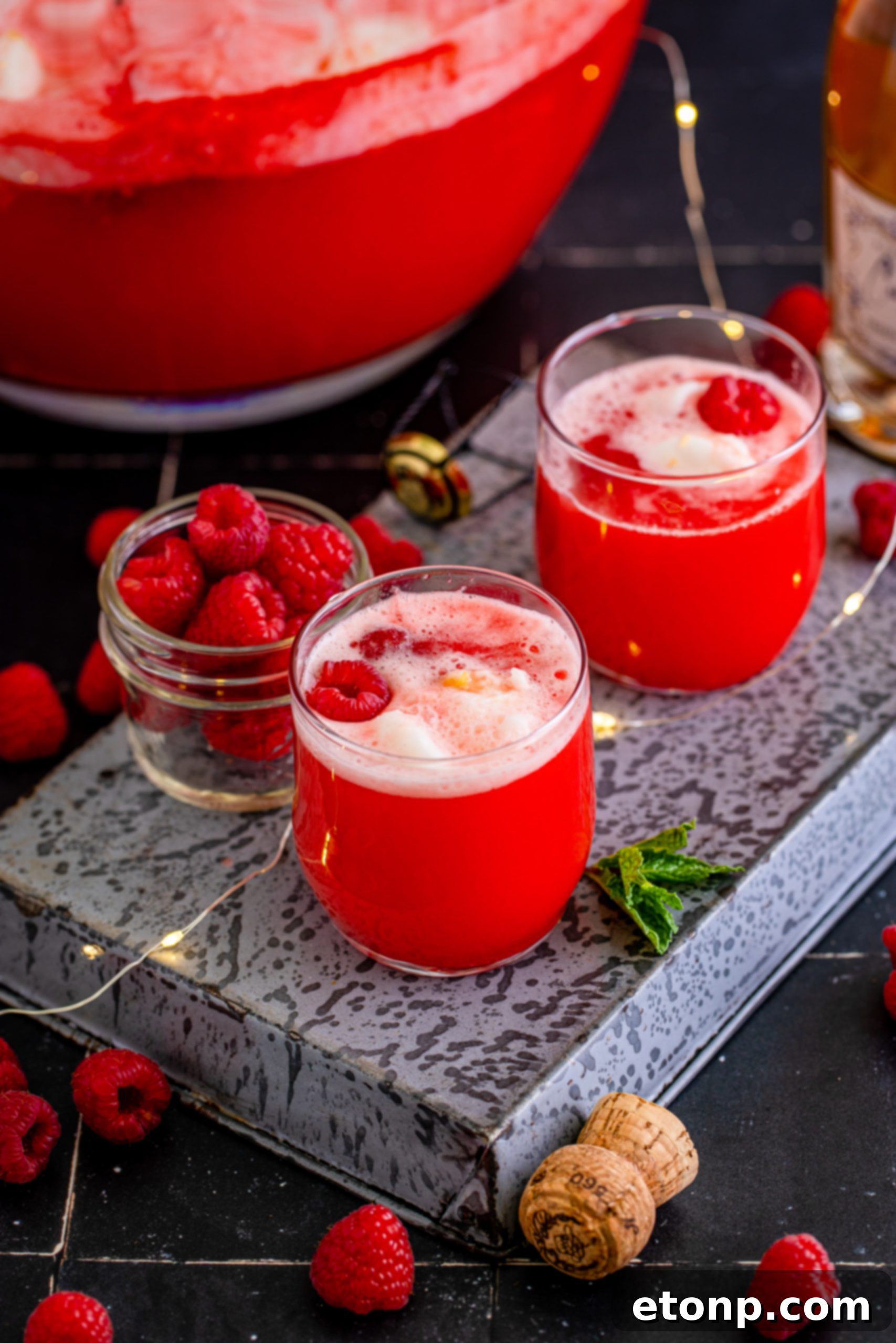 Close up of Boozy Sherbet Punch in a glass, with vibrant red and yellow hues