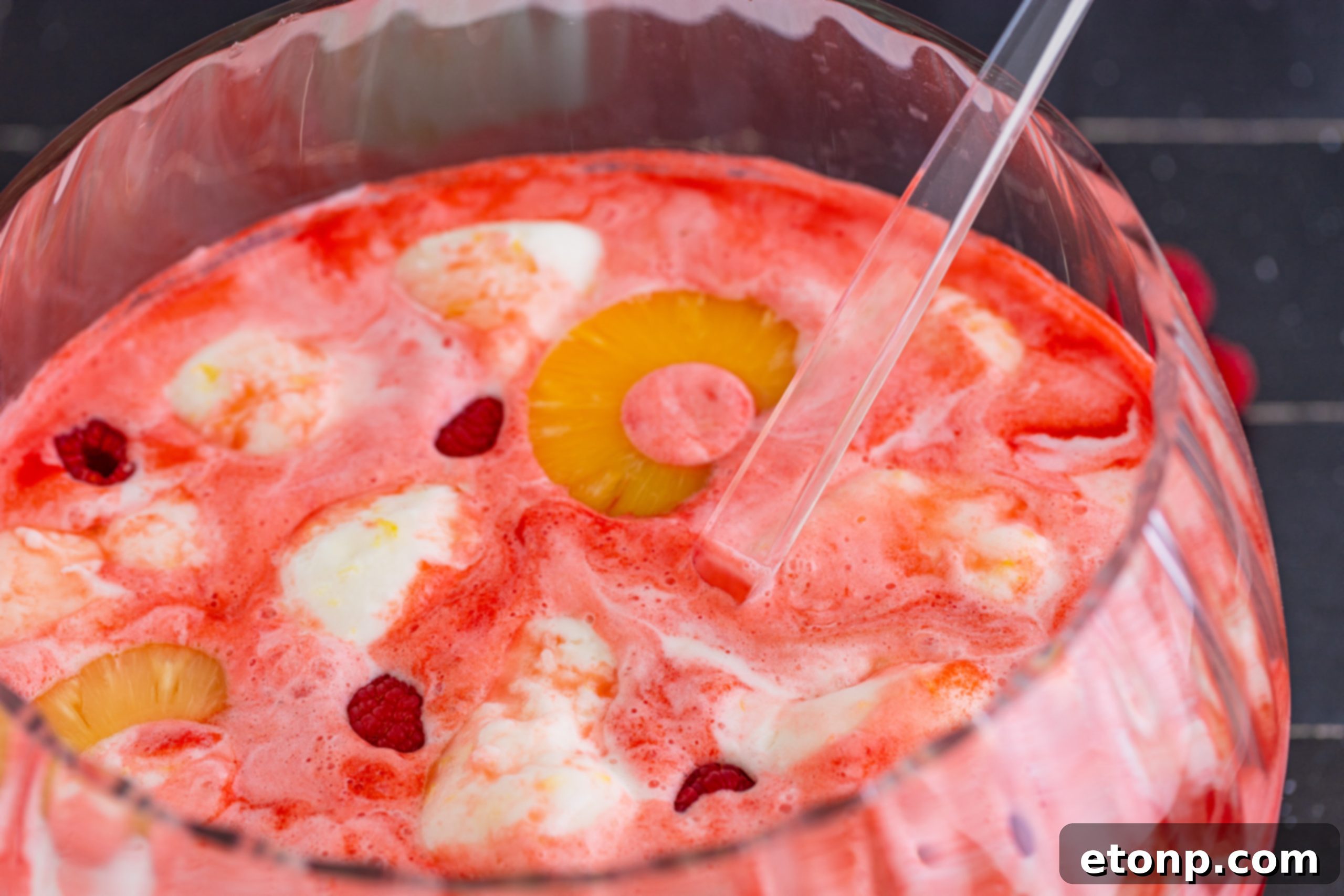 Overhead view of Boozy Sherbet Punch bowl with a ladle and surrounded by glasses