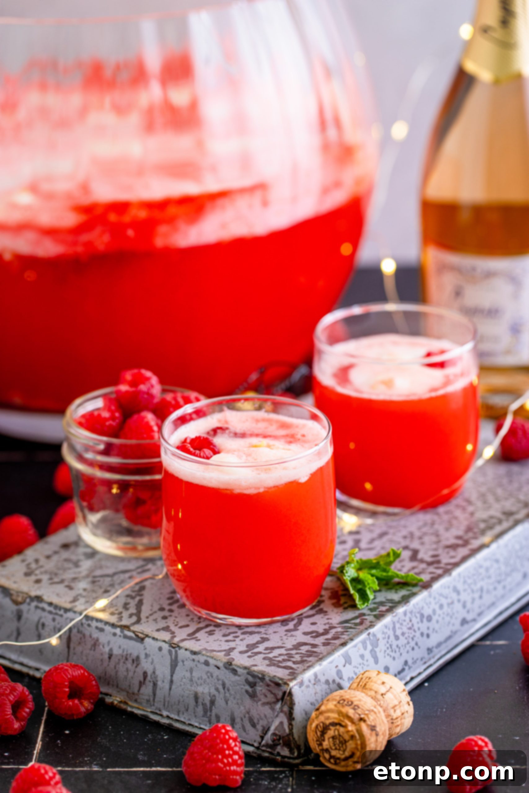 A large bowl of Boozy Sherbet Punch being stirred with a ladle