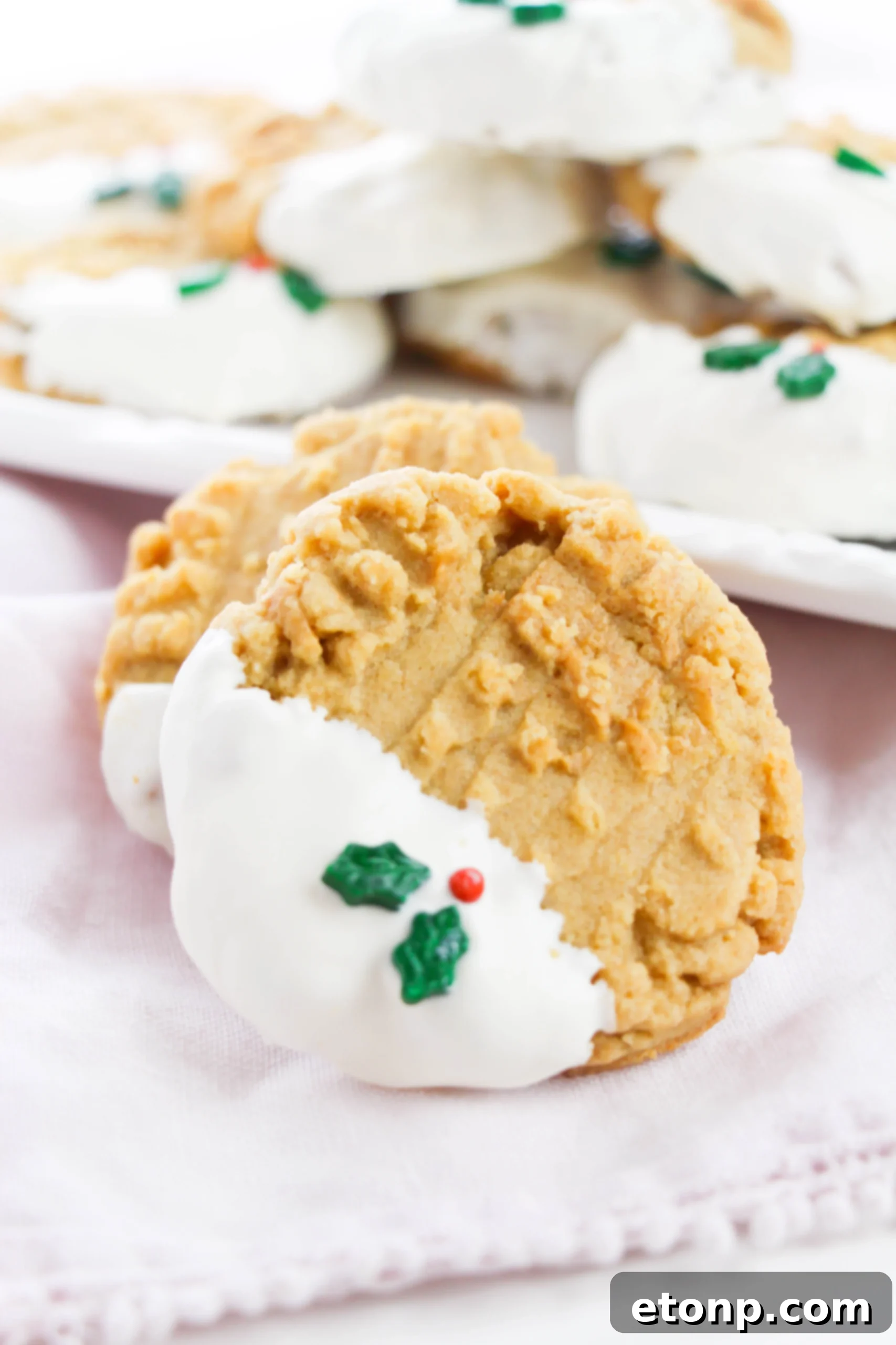 Silky White Chocolate Peanut Butter Cookies 4 Stack of freshly baked white chocolate dipped peanut butter cookies on a cooling rack