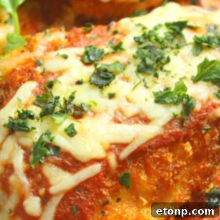 Baked Chicken Parmesan with melted cheese and fresh basil