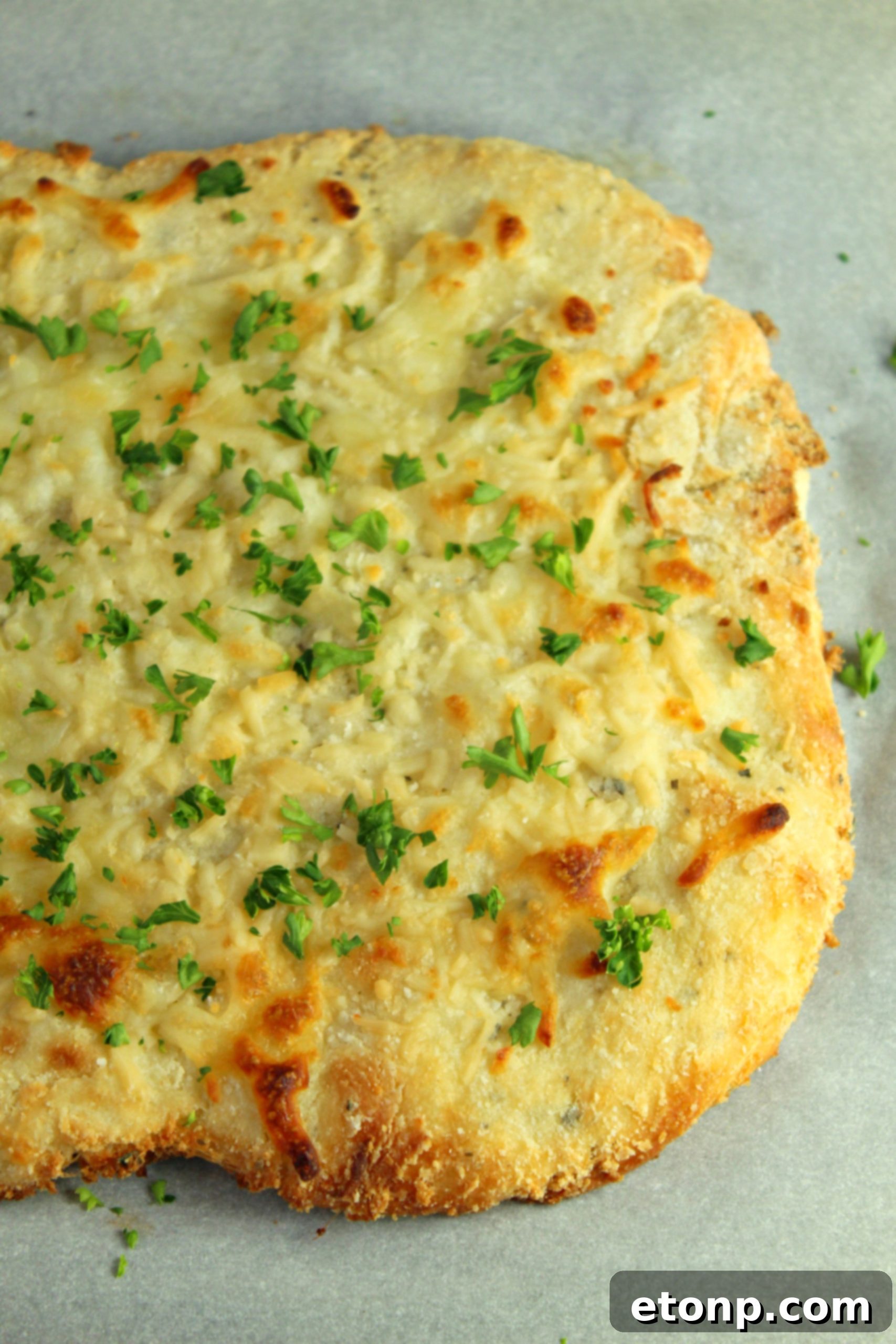 Four Cheese Keto Breadsticks Deliciously Low Carb 4 A stack of freshly baked Four Cheese Keto Breadsticks, garnished with fresh parsley.