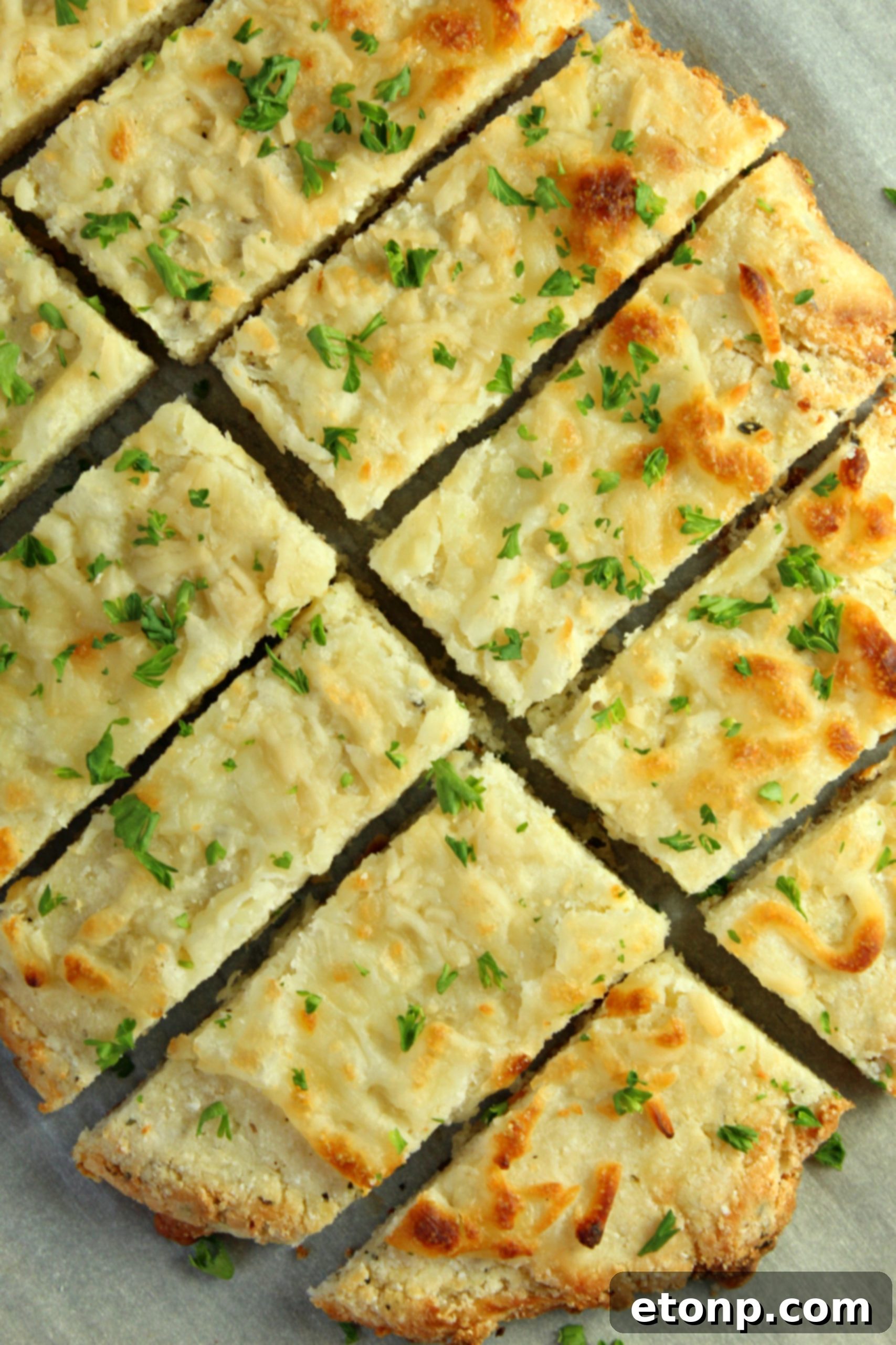 Four Cheese Keto Breadsticks Deliciously Low Carb 5 Four Cheese Keto Breadsticks laid out on parchment paper, fresh out of the oven, waiting to be served.