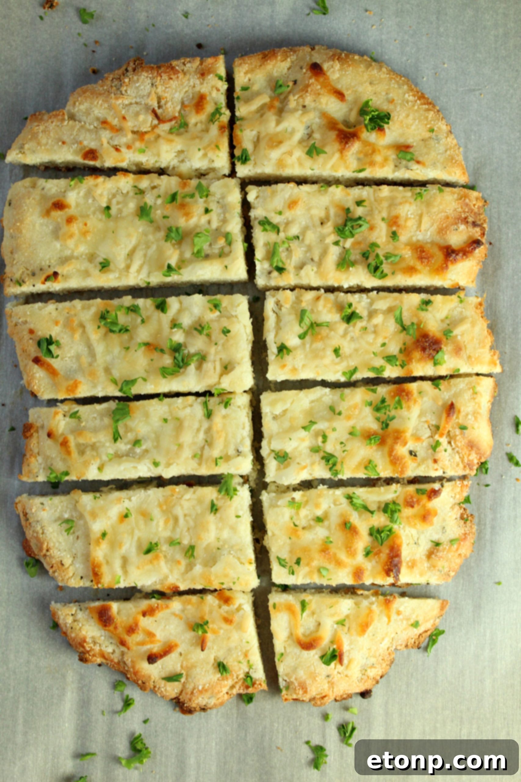 Four Cheese Keto Breadsticks Deliciously Low Carb 6 A close-up view of the golden, slightly browned crust of a Four Cheese Keto Breadstick, emphasizing its crispiness.