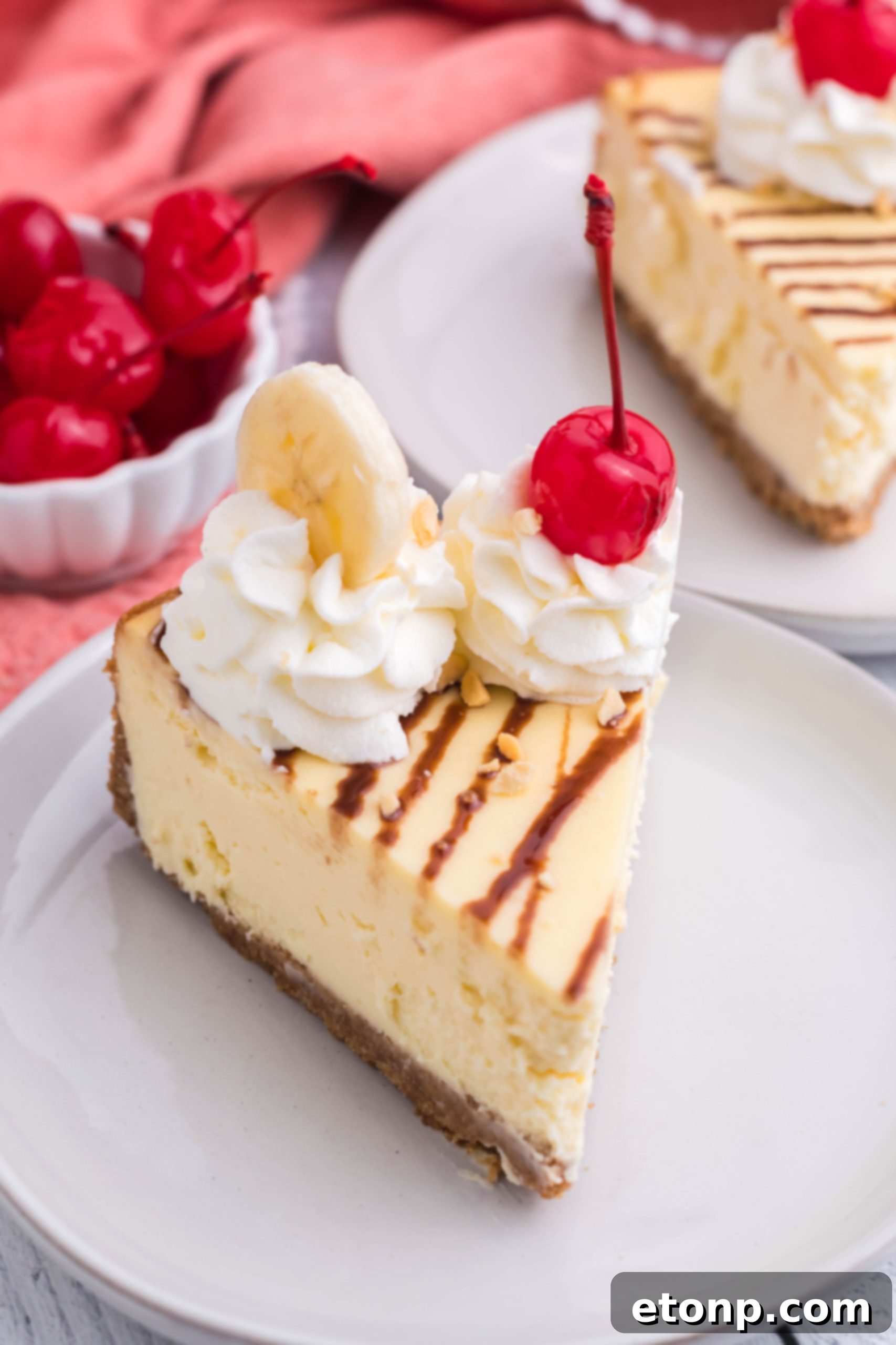 A large, beautifully crafted Banana Split Cheesecake sitting on a countertop, ready for serving or storage, with its rich toppings enticingly arranged.