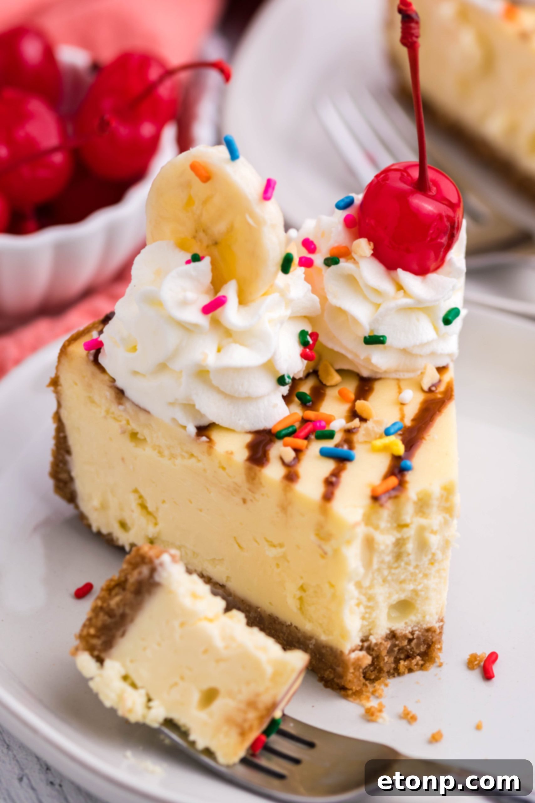 An inviting view of the Banana Split Cheesecake, ready to be sliced and served. The vibrant toppings contrast beautifully with the creamy, light-colored cheesecake.