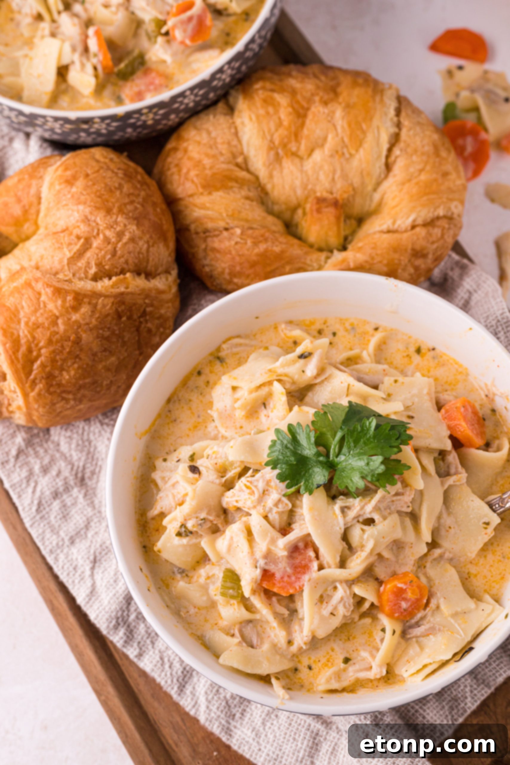 A large pot filled with creamy chicken noodle soup simmering on the stove, steam rising.