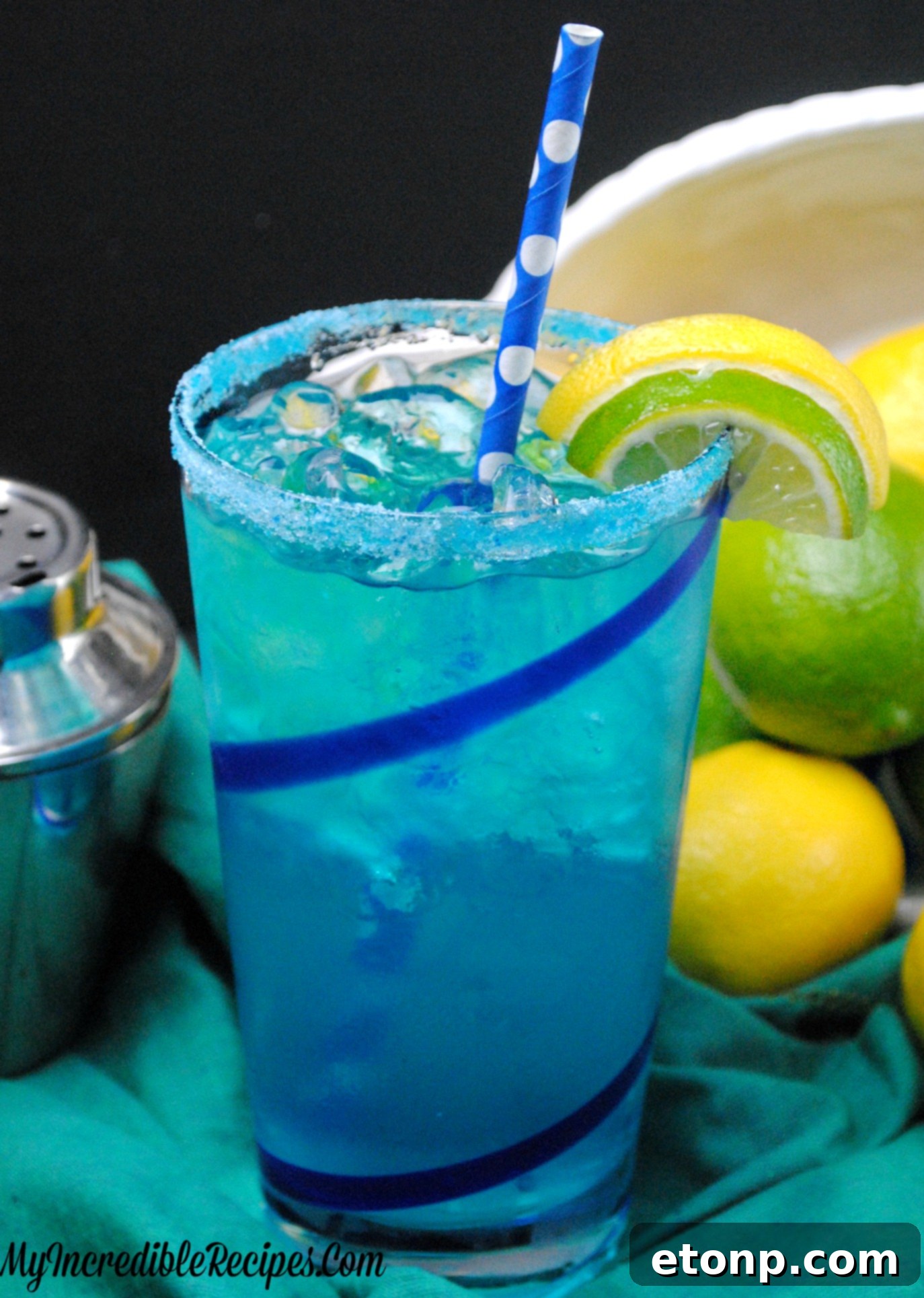 Enjoying Electric Lemonade A hand holding a tall glass of Electric Lemonade, with ice and garnishes clearly visible, ready to be enjoyed.