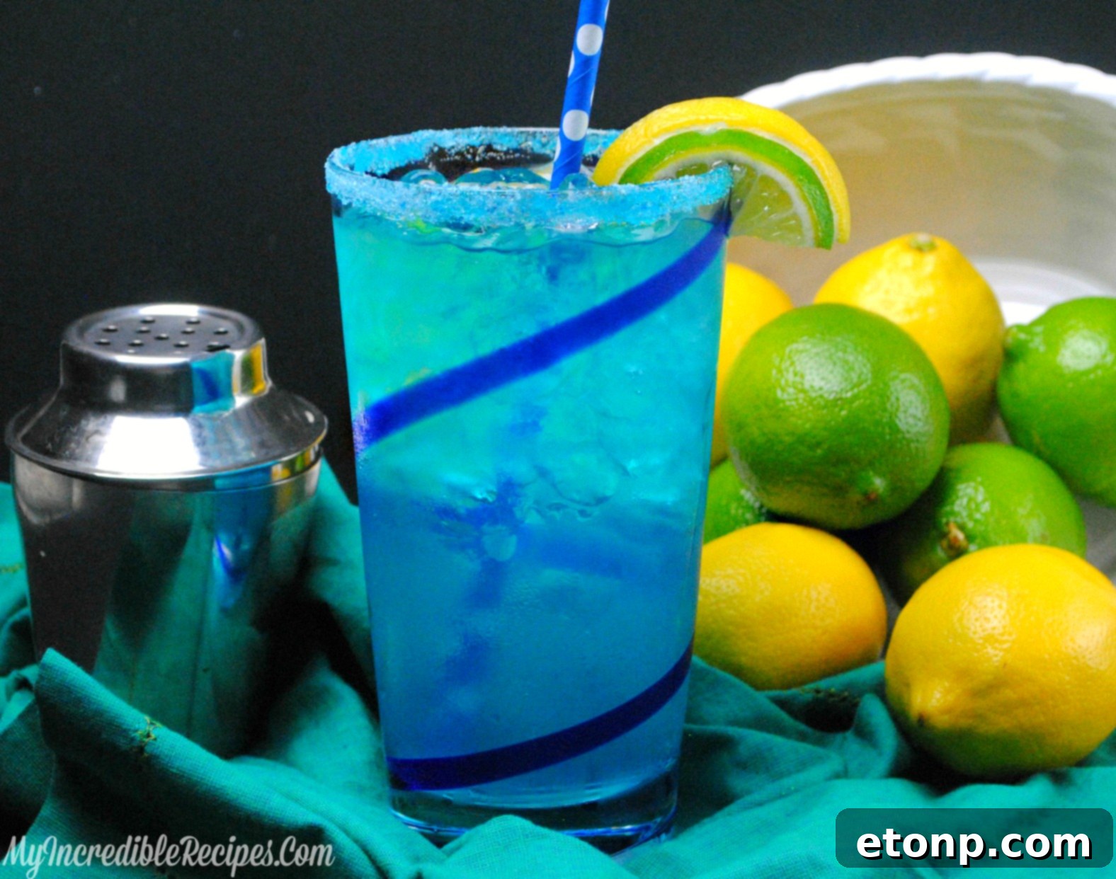 Beautifully Presented Blue Drinks Two glasses of Electric Lemonade, elegantly presented on a tabletop, garnished with fruit slices, highlighting their beautiful blue color.