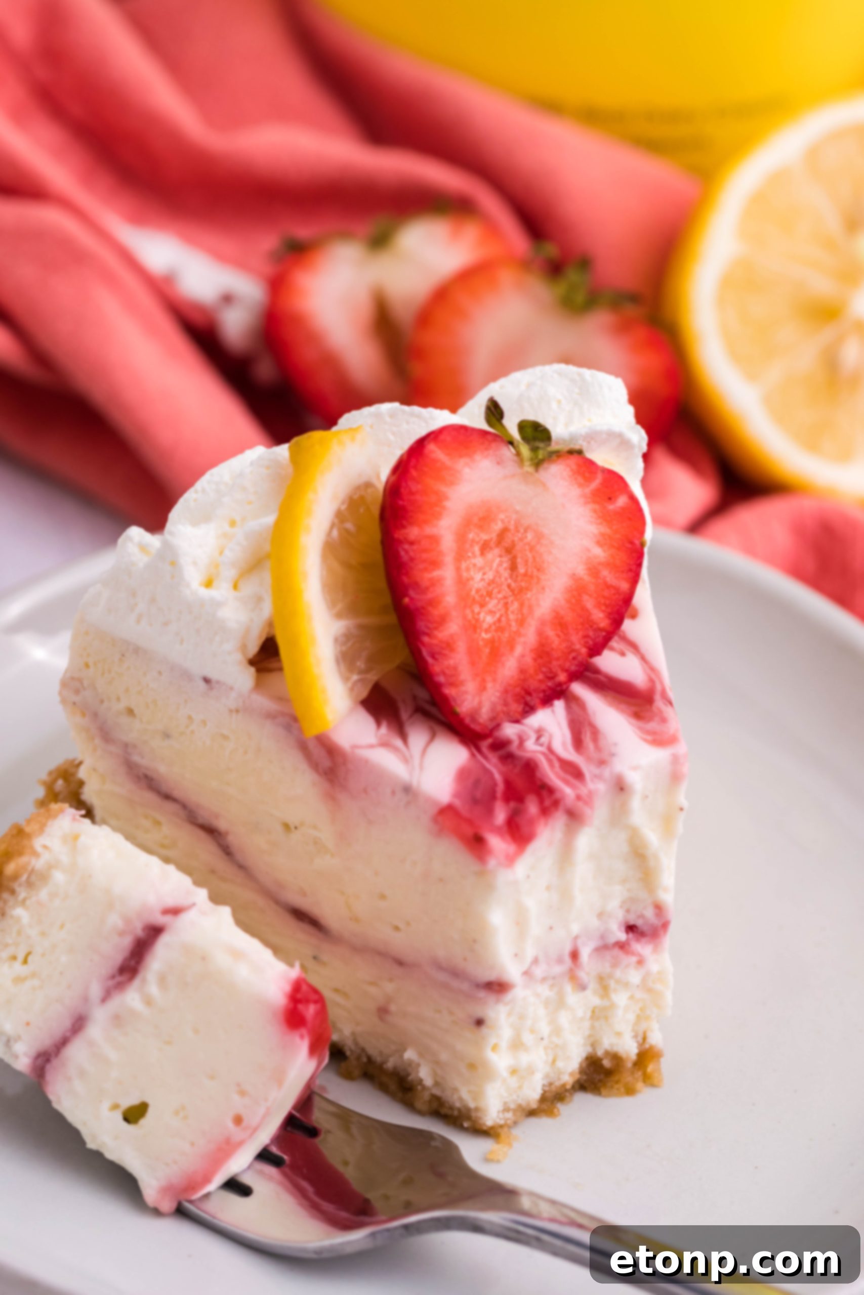 An inviting overhead shot of the entire Strawberry Lemon RumChata Cheesecake, generously adorned with an abundance of fluffy whipped cream, fresh fruit, and vibrant garnishes, ready to be served.