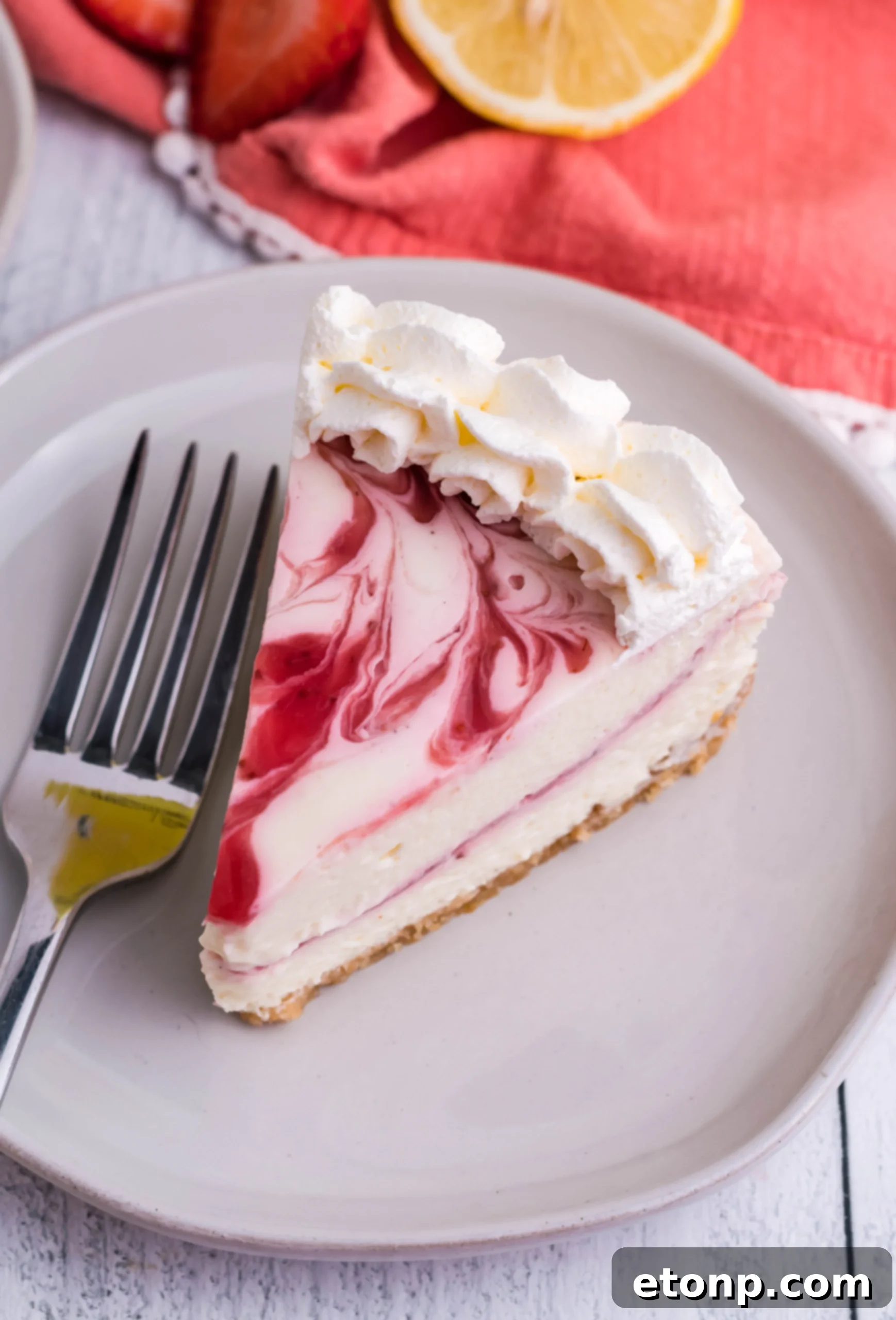 A stunning, close-up photograph of a fully decorated Strawberry Lemon RumChata Cheesecake, perfectly prepared and ready for serving, highlighting the intricate details of the whipped cream and fresh fruit garnishes.