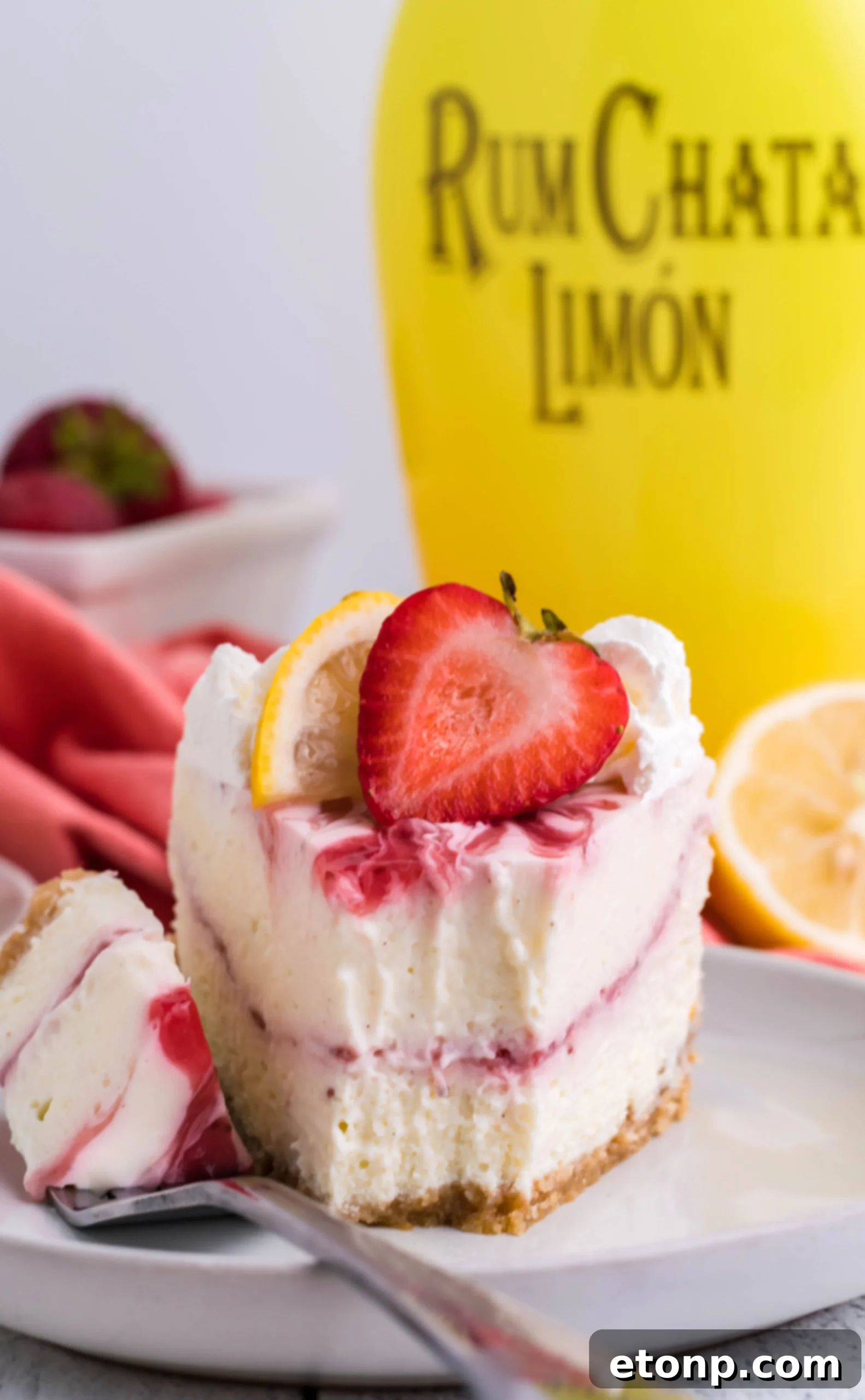 A final, absolutely delicious looking shot of the Instant Pot Strawberry Lemon RumChata Cheesecake, perfectly garnished and ready to be served, with its inviting toppings beautifully visible.