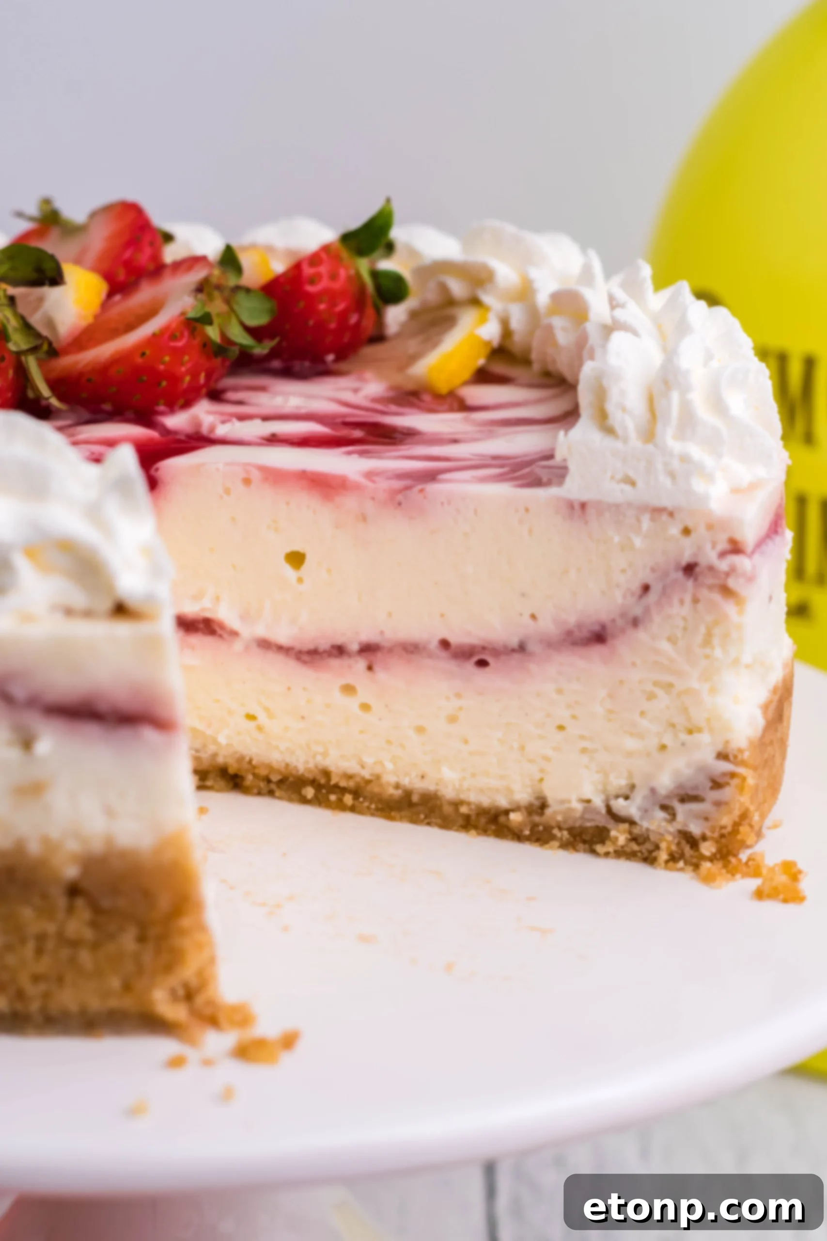 A close-up shot revealing the luxurious creamy texture and the exquisite strawberry swirl patterns within the Instant Pot Strawberry Lemon RumChata Cheesecake.