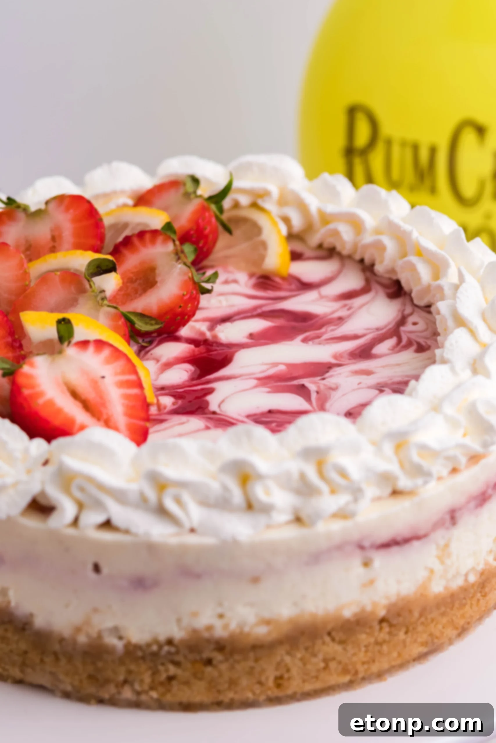Multiple delectable slices of Strawberry Lemon RumChata Cheesecake arranged neatly on a serving platter, highlighting the golden crust and sumptuously creamy filling.