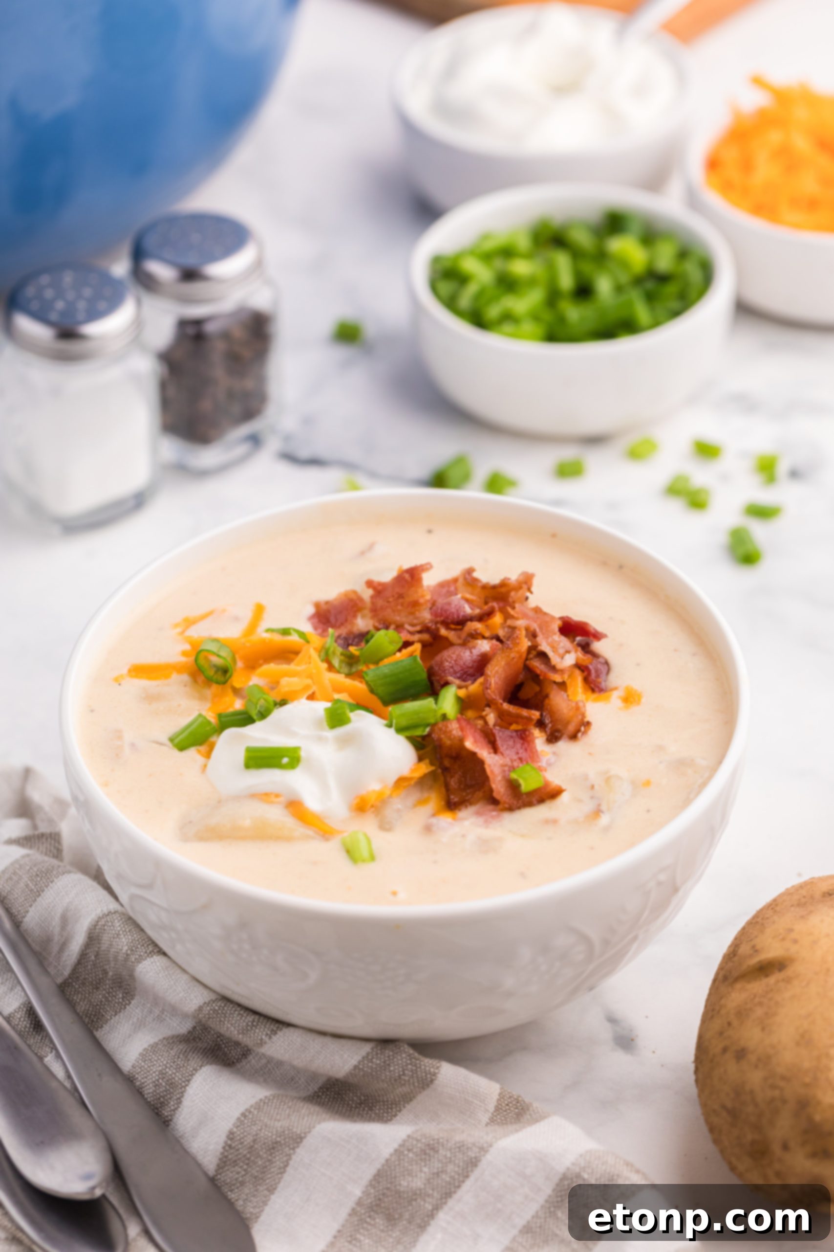 Bowl of Loaded Baked Potato Soup garnished with bacon and chives