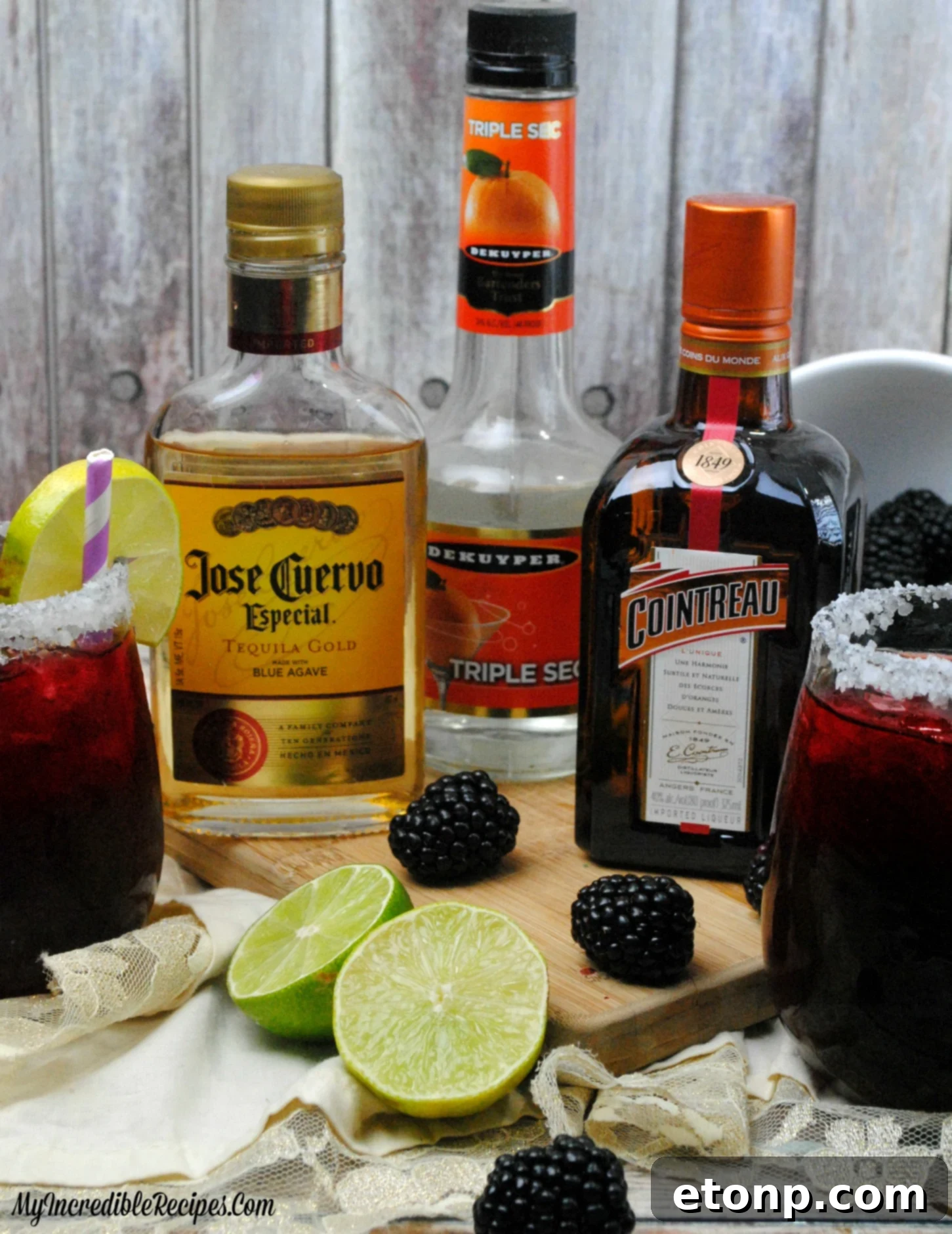 A hand holding a frosty glass of Blackberry Margarita, emphasizing its refreshing appeal.