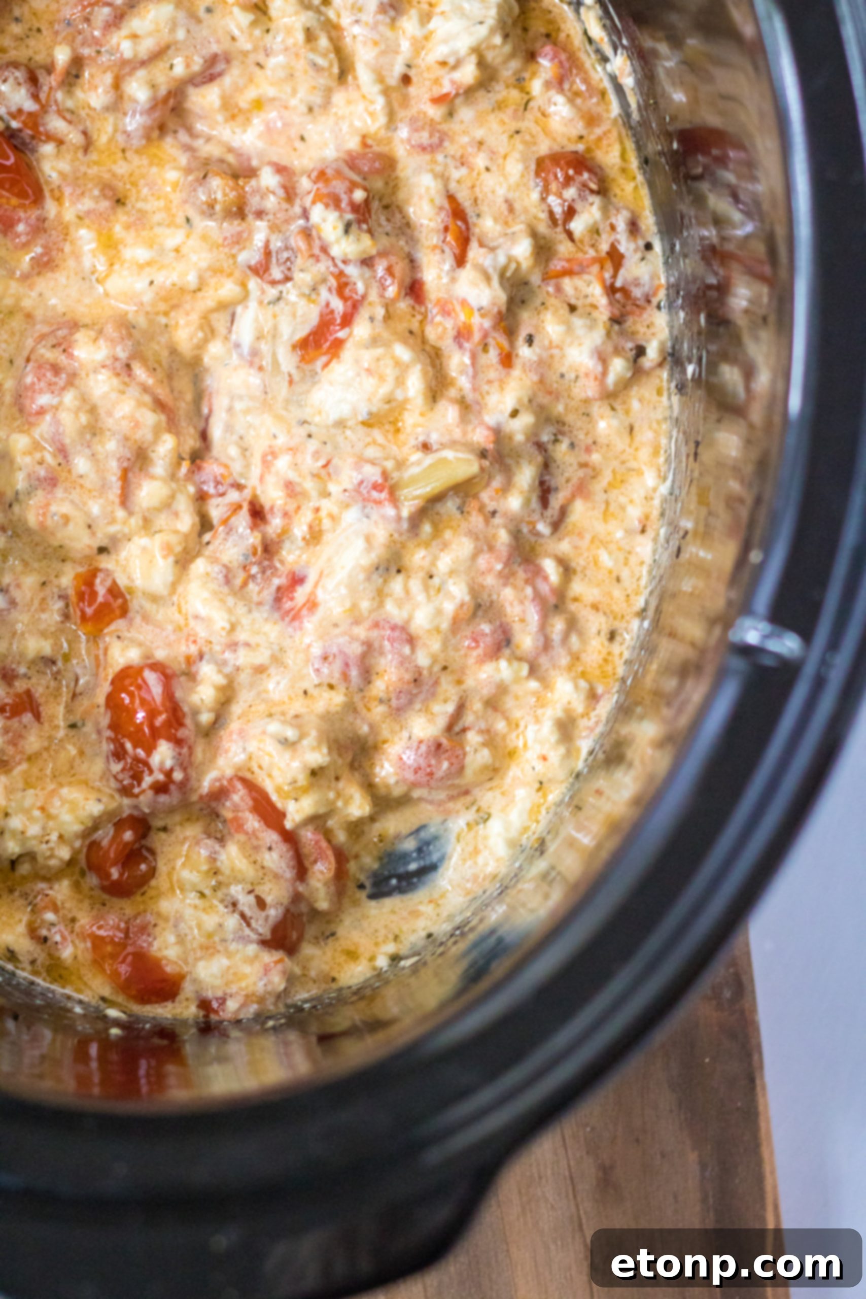 Slow Cooker Tomato Feta Pasta with fresh basil garnish