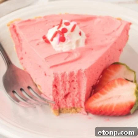 A circular image of the finished Strawberry Kool-Aid Pie, perfectly garnished with whipped cream and strawberries.