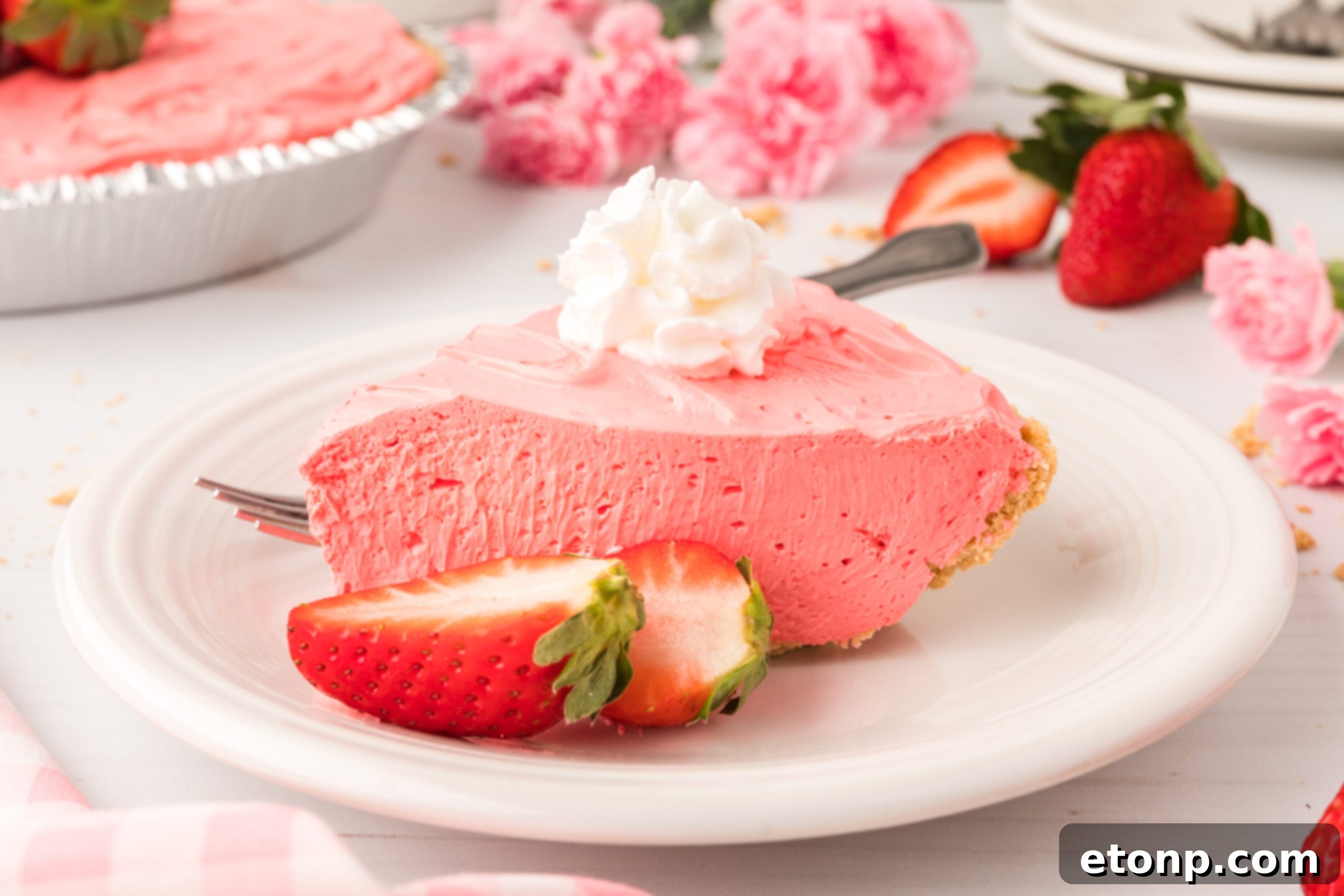 A whole no-bake Strawberry Kool-Aid pie, freshly made and ready for chilling, showcasing its vibrant pink filling against the golden graham cracker crust.