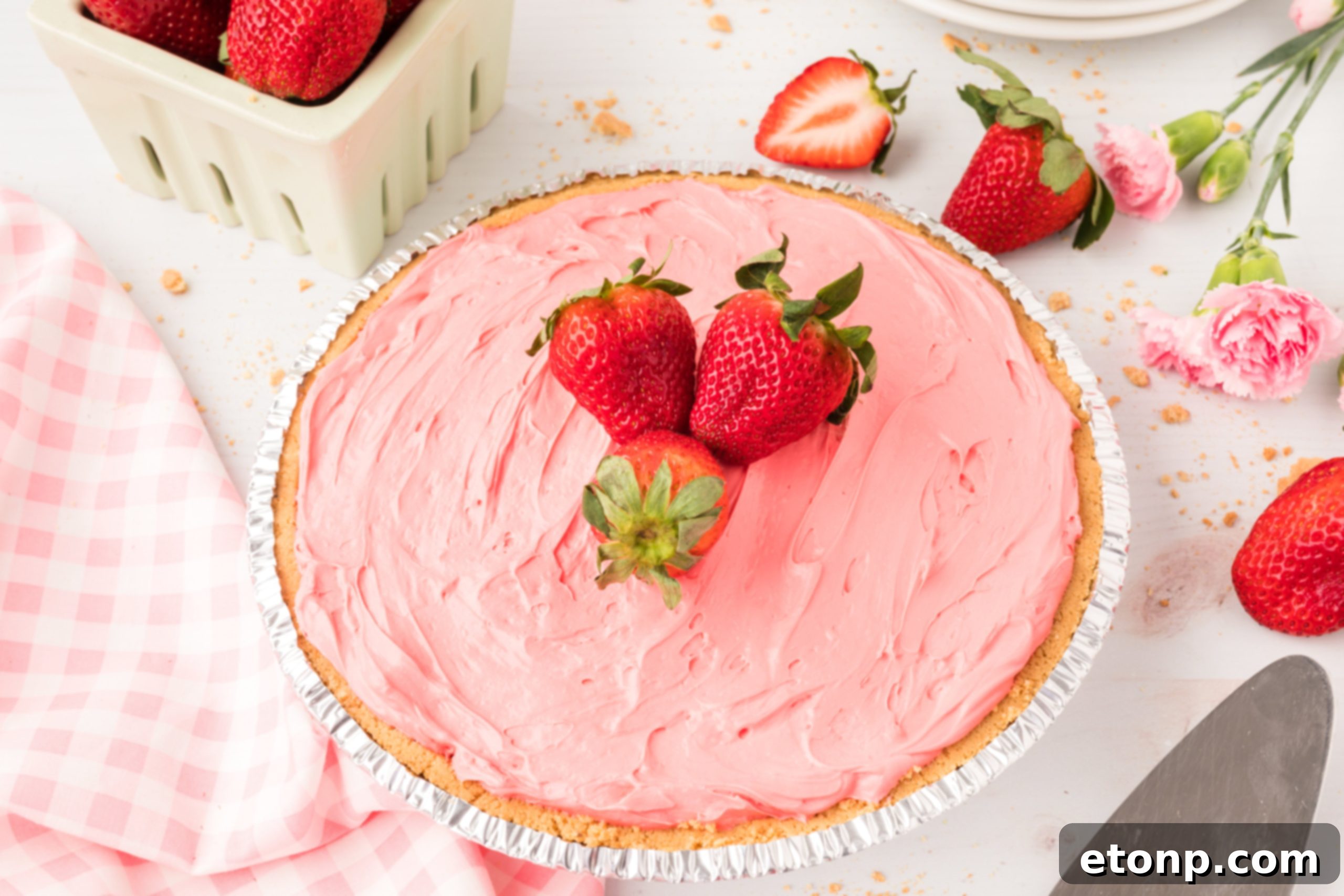 An assortment of ingredients for Strawberry Kool-Aid pie laid out on a kitchen counter, including cream cheese, sweetened condensed milk, Kool-Aid powder, and whipped topping.