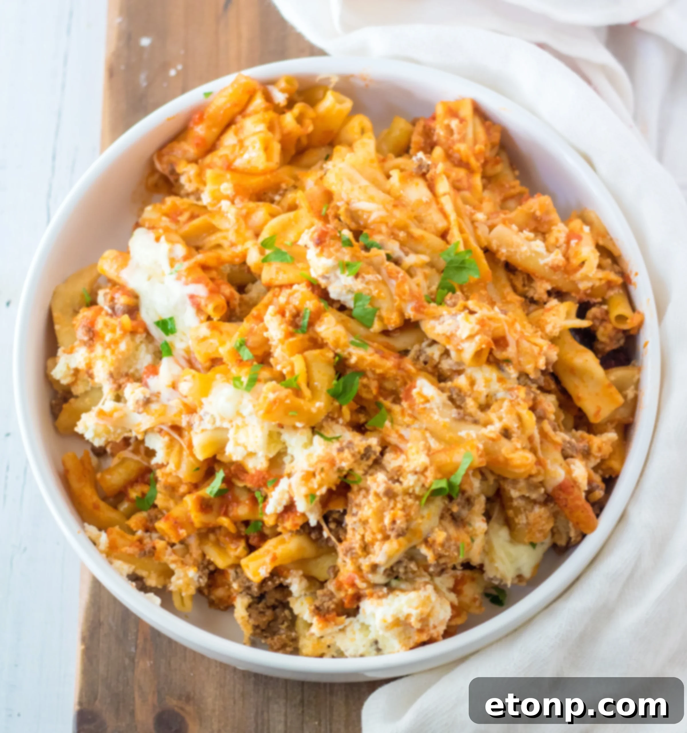 Finished Slow Cooker Cheesy Baked Pasta in the crock pot, garnished with fresh basil leaves.