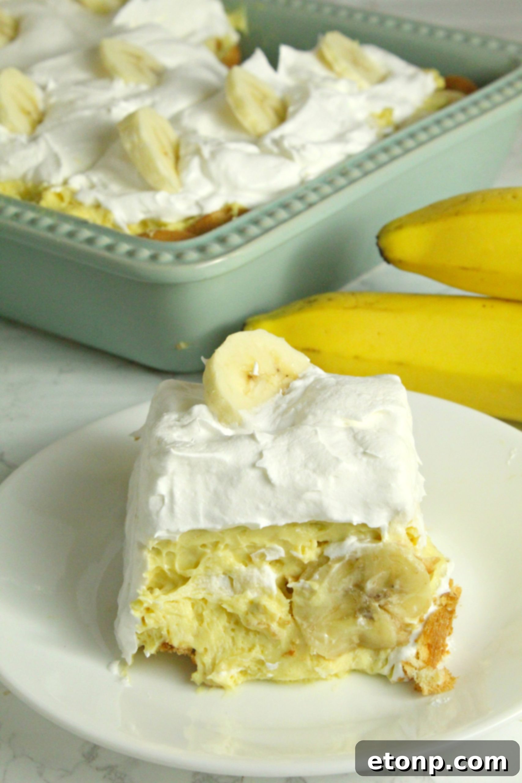 Fresh banana slices being added to the top of the pudding