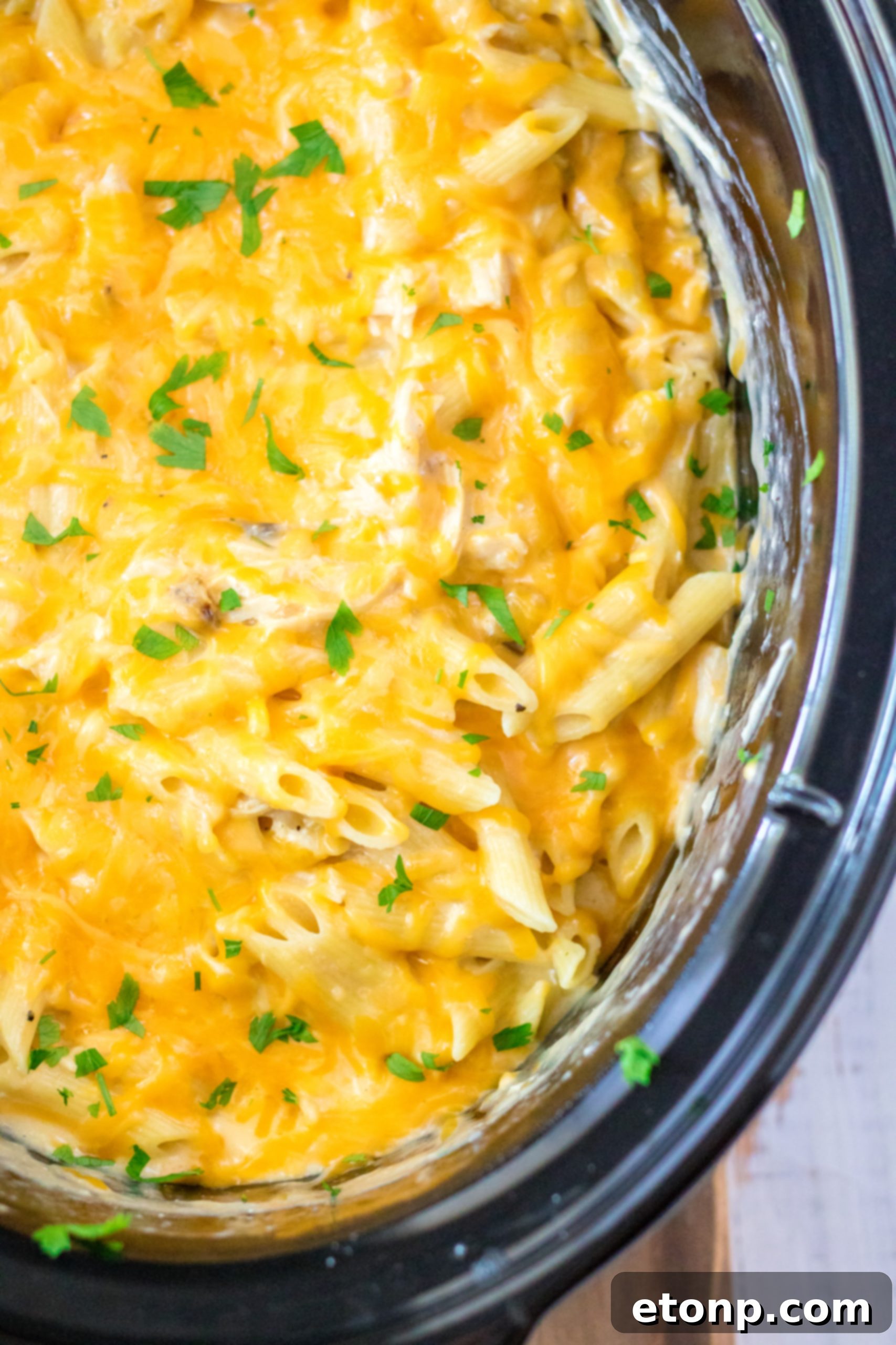 Effortless Slow Cooker Cheesy Chicken Penne 14 A bowl of Slow Cooker Cheesy Chicken Penne, garnished with fresh herbs