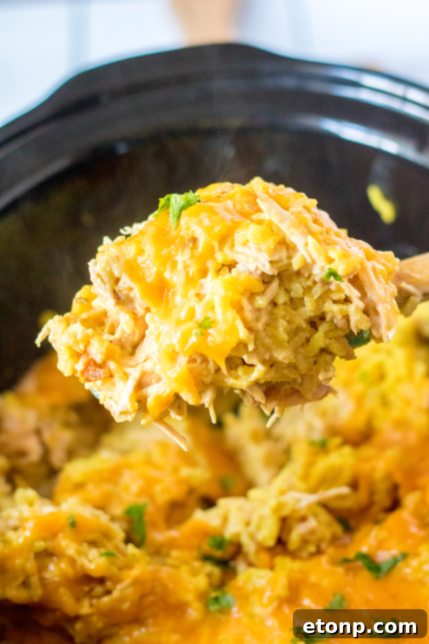A delicious bowl of slow cooker cheesy chicken and rice, garnished with fresh parsley.