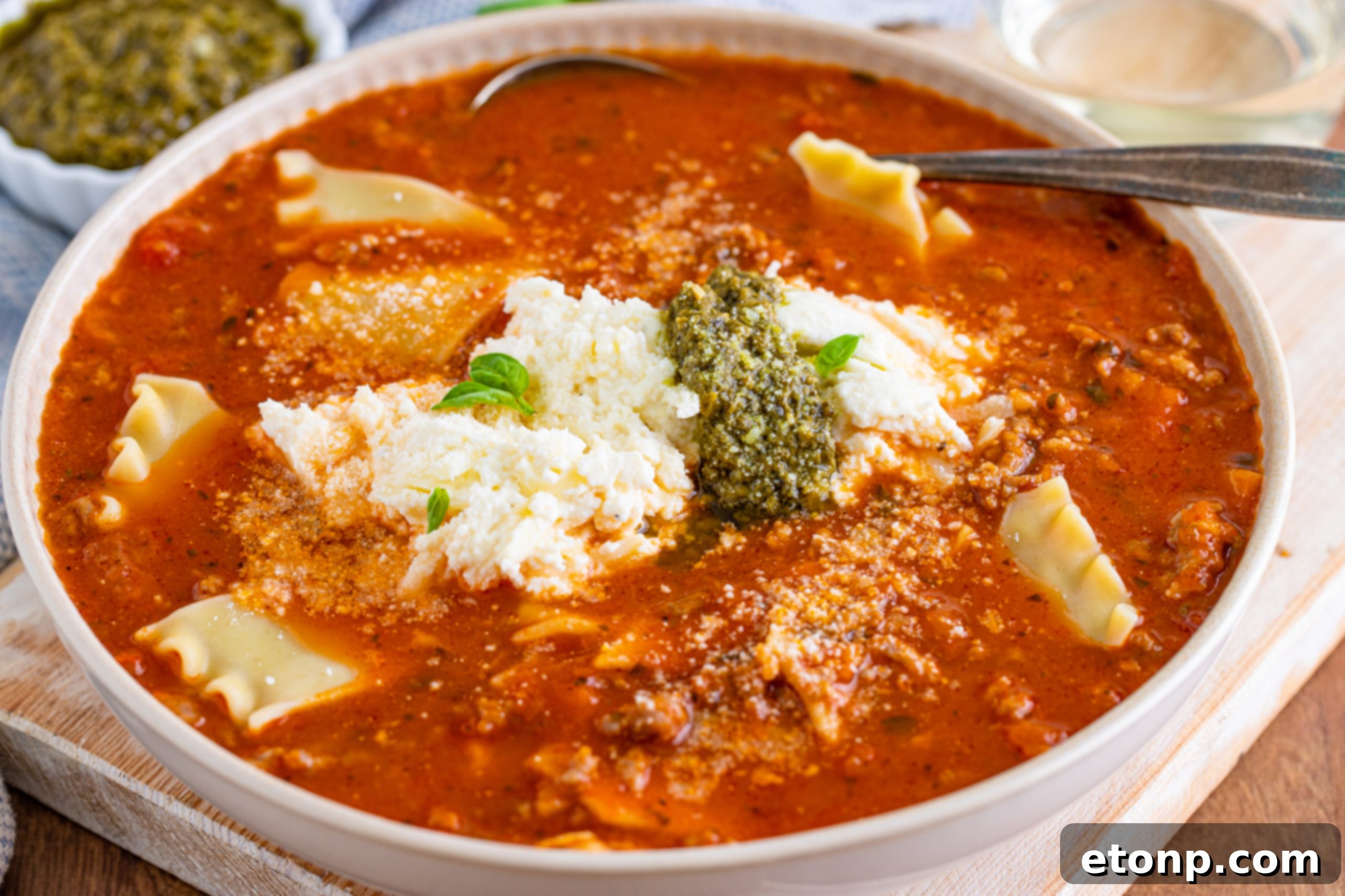 Assortment of Lasagna Soup ingredients laid out on a table, including crushed tomatoes and sauce.