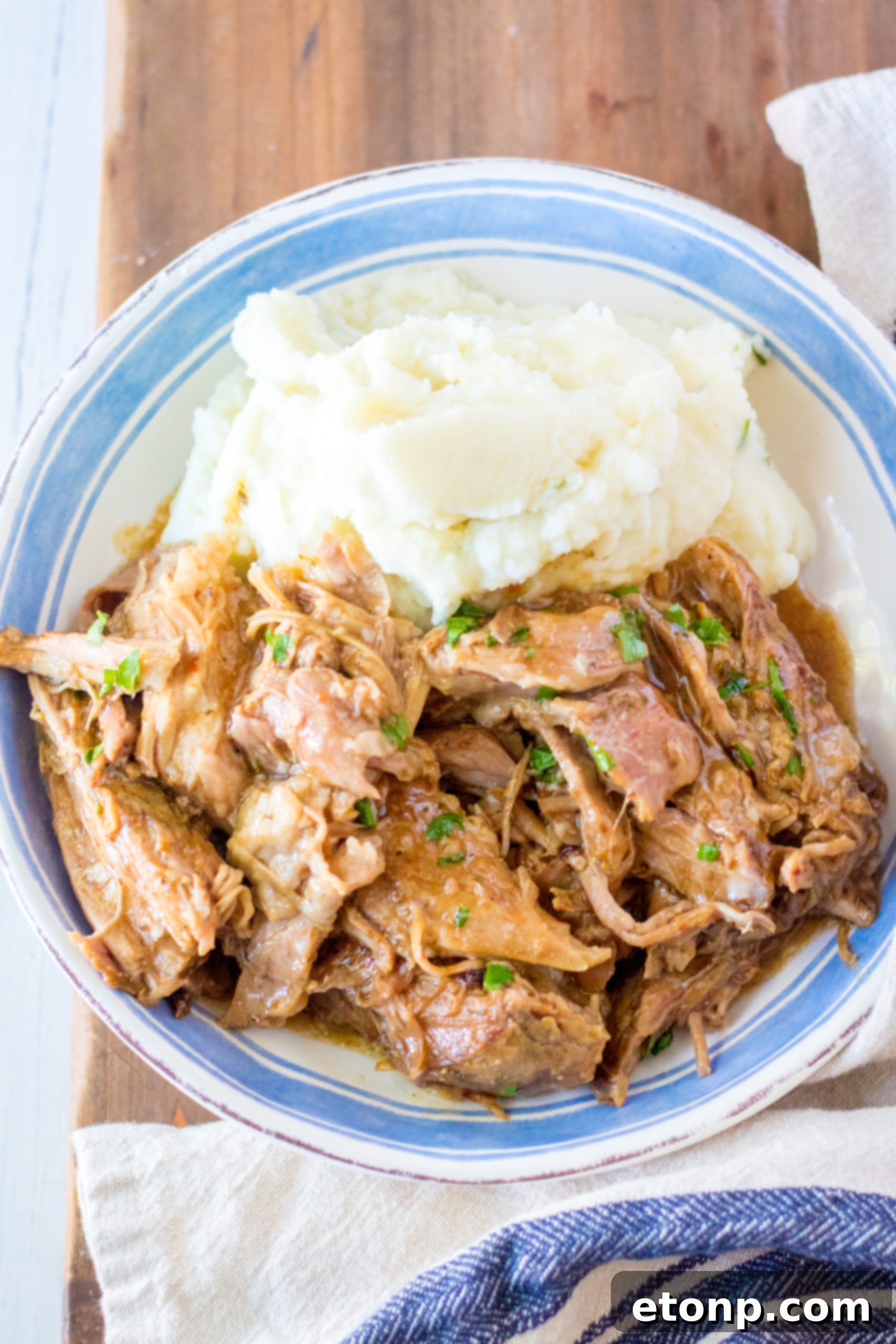 Slow cooker 3 packet pork roast served on a plate with mashed potatoes and green beans