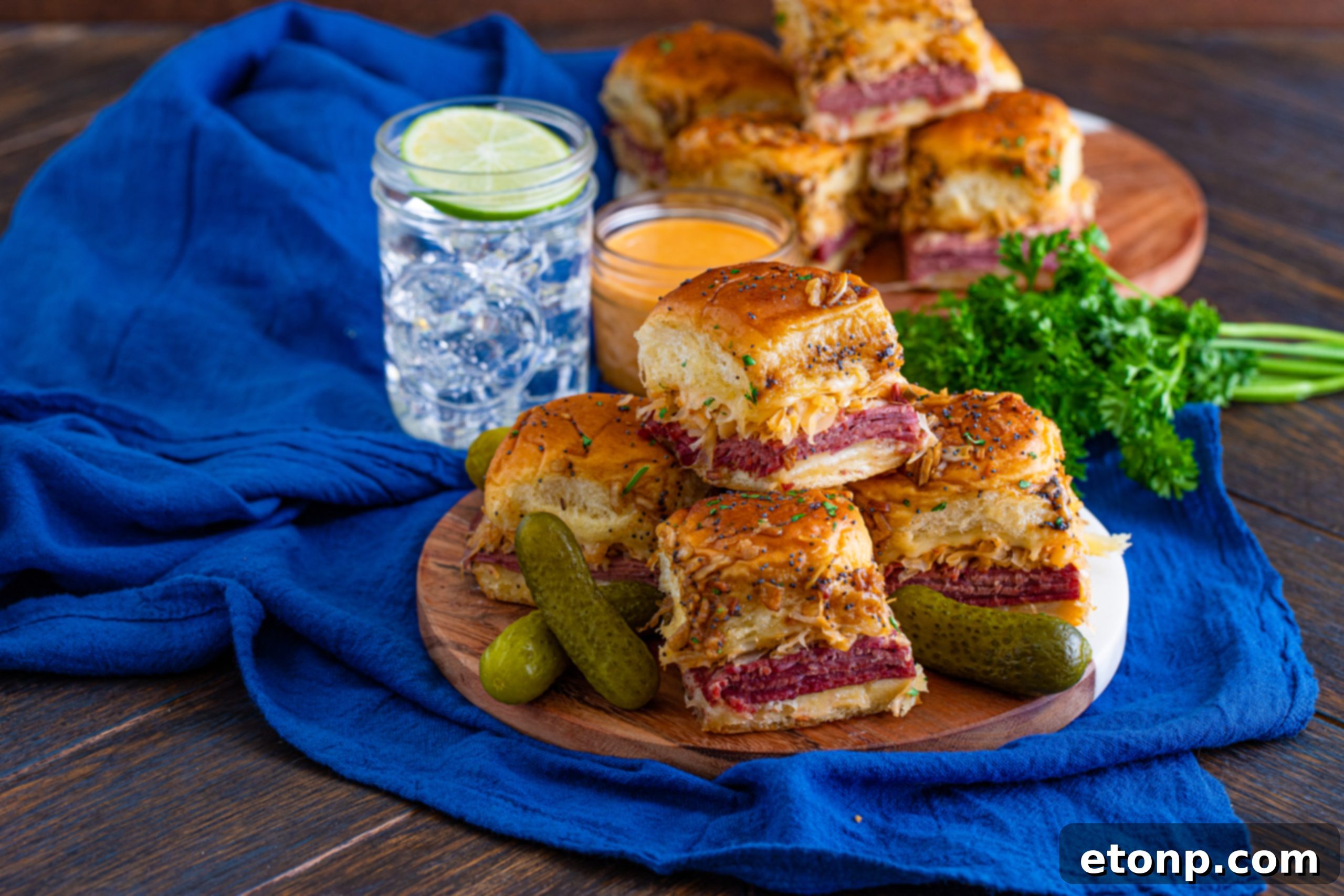 Mini Reuben Sandwiches 14 A large platter of baked Reuben Sliders, beautifully sliced and arranged, ready to be served to guests.