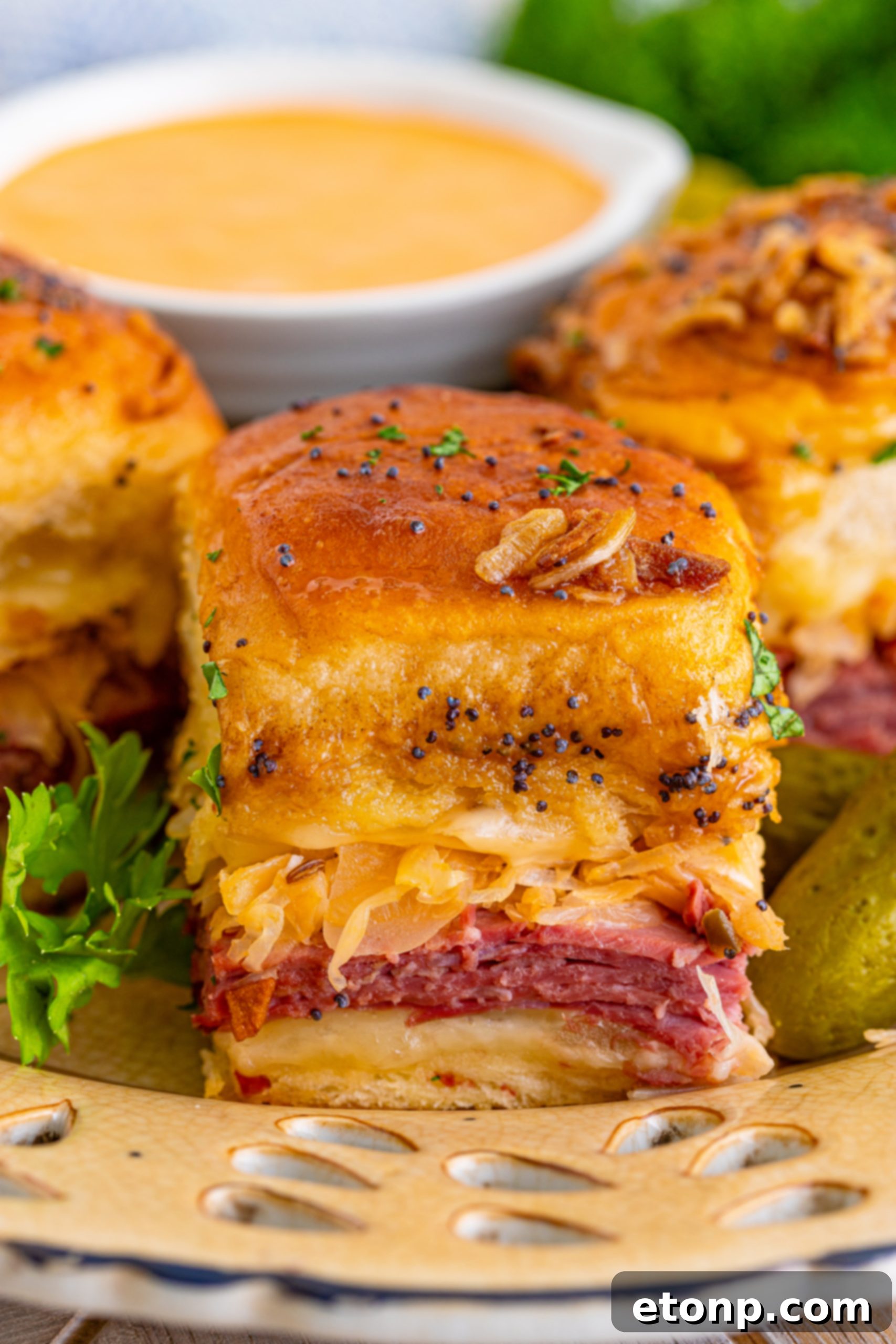 Mini Reuben Sandwiches 20 A close-up shot of a baked Reuben Slider on a white plate, showcasing its golden crust and delicious filling.