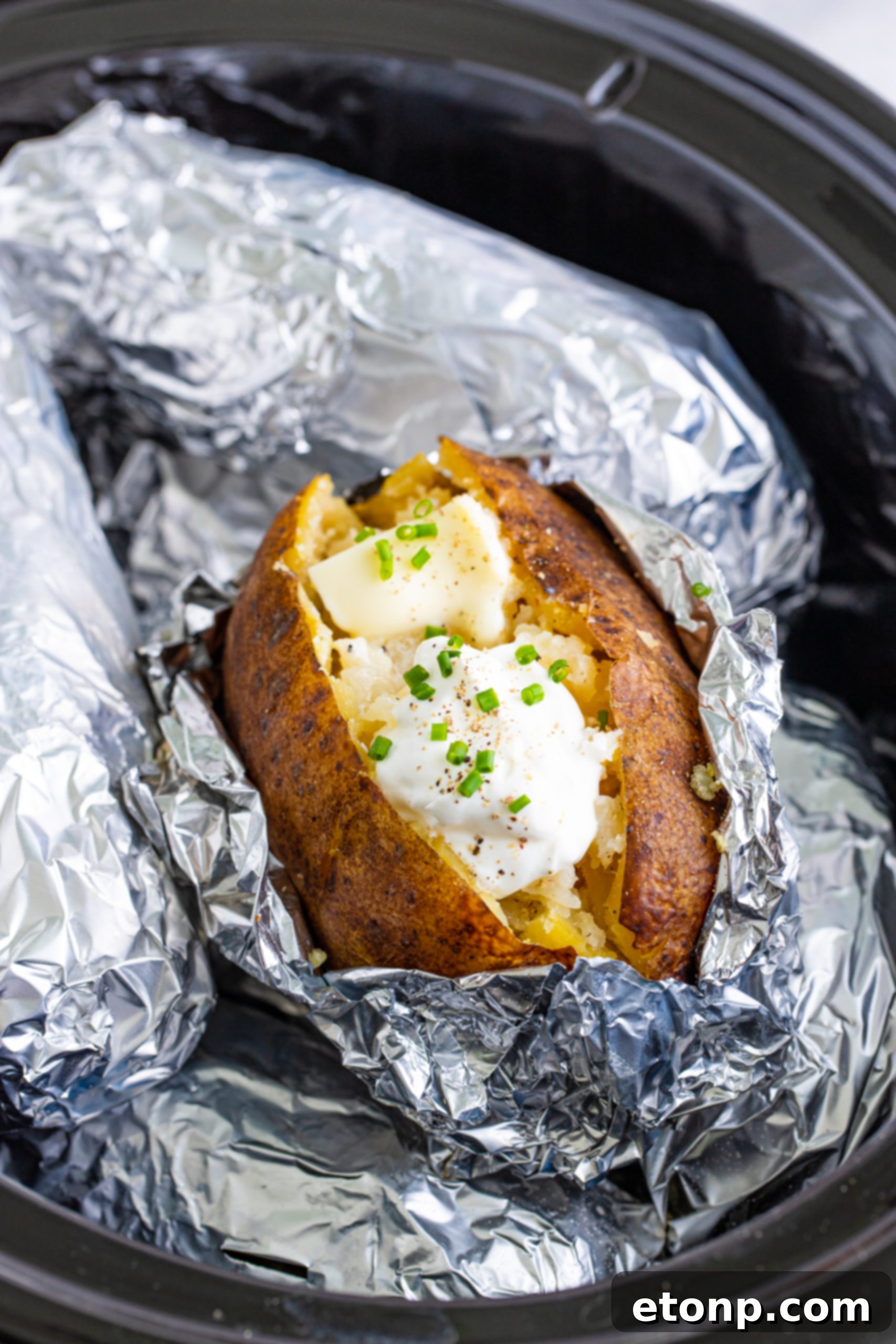 Two plates with baked potatoes, steak, and green beans
