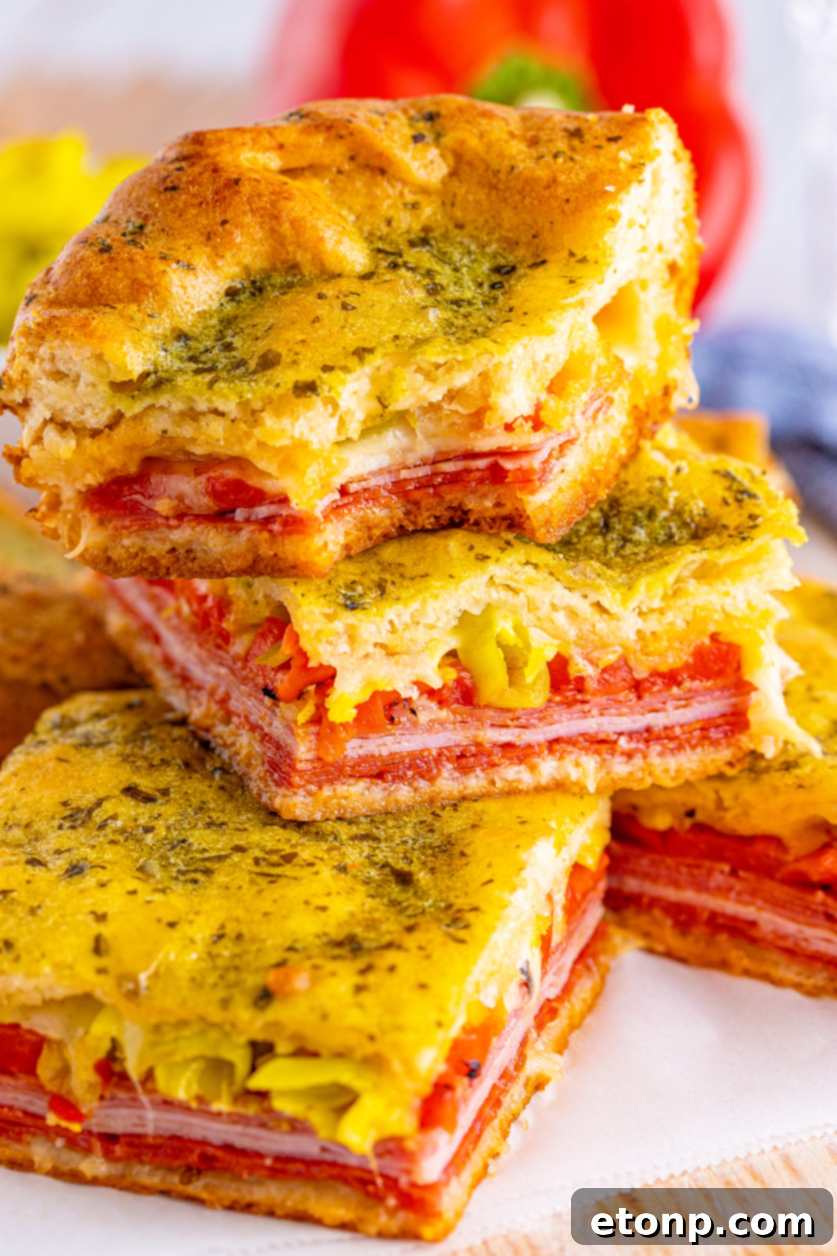 Deliciously baked Italian Antipasto Squares, a perfect appetizer or main course, garnished with fresh herbs.