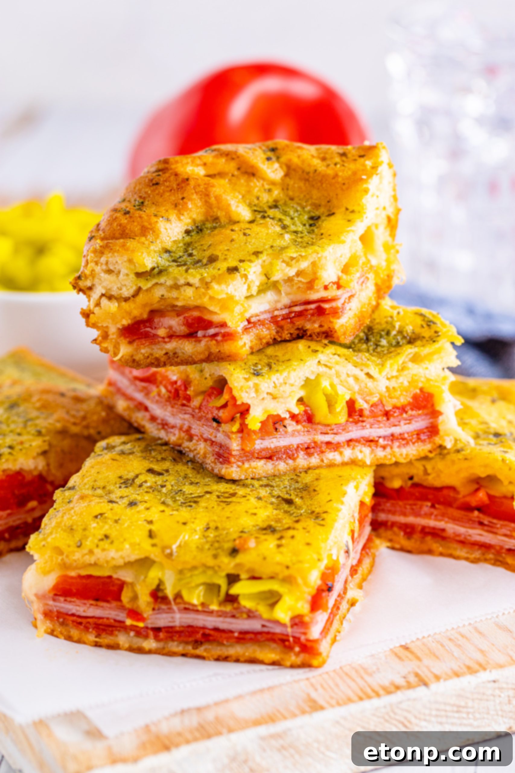 A large tray of freshly baked Italian Antipasto Squares, sliced and ready for serving.
