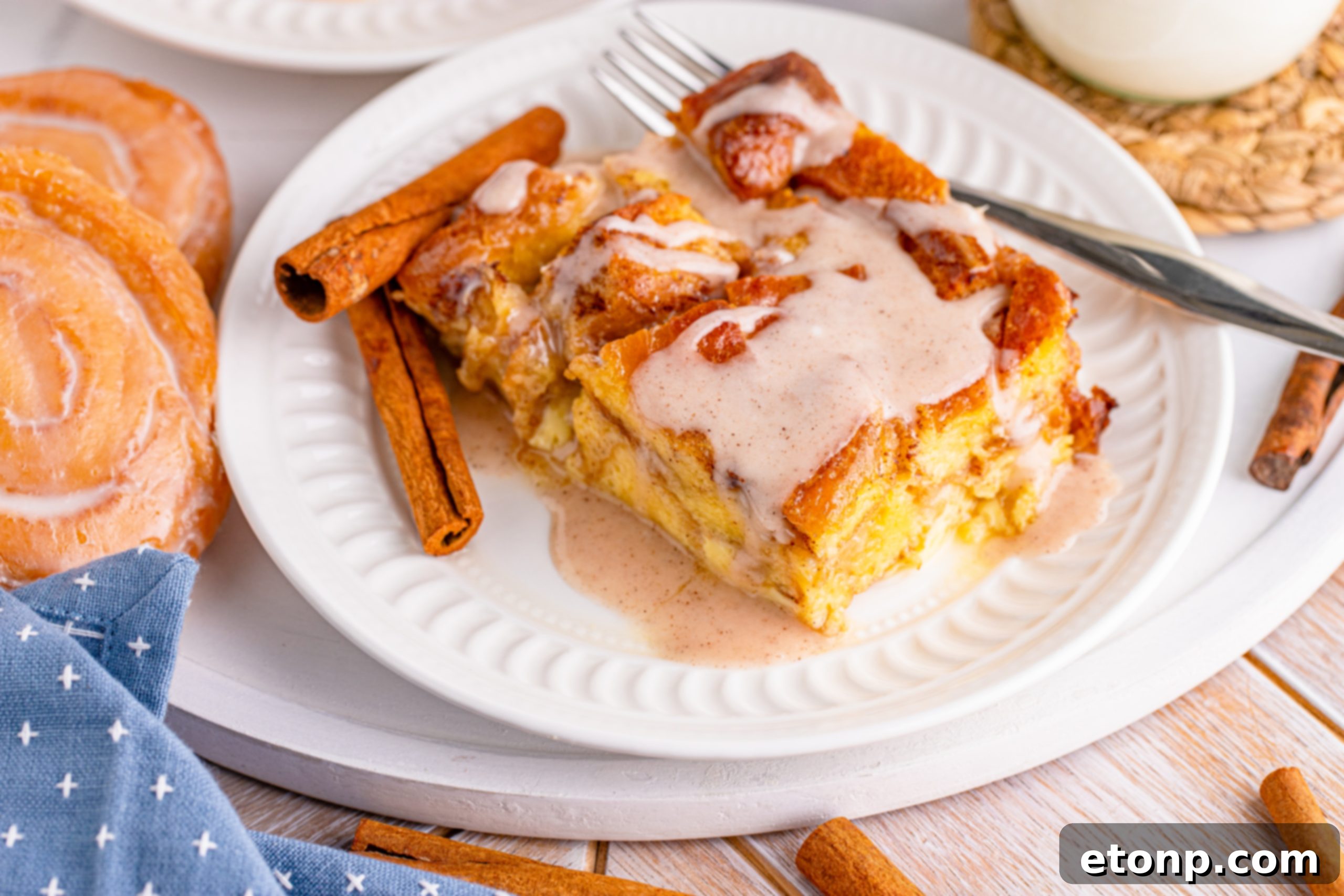 Warm Glazed Honeybun Bread Pudding being drizzled with cinnamon glaze