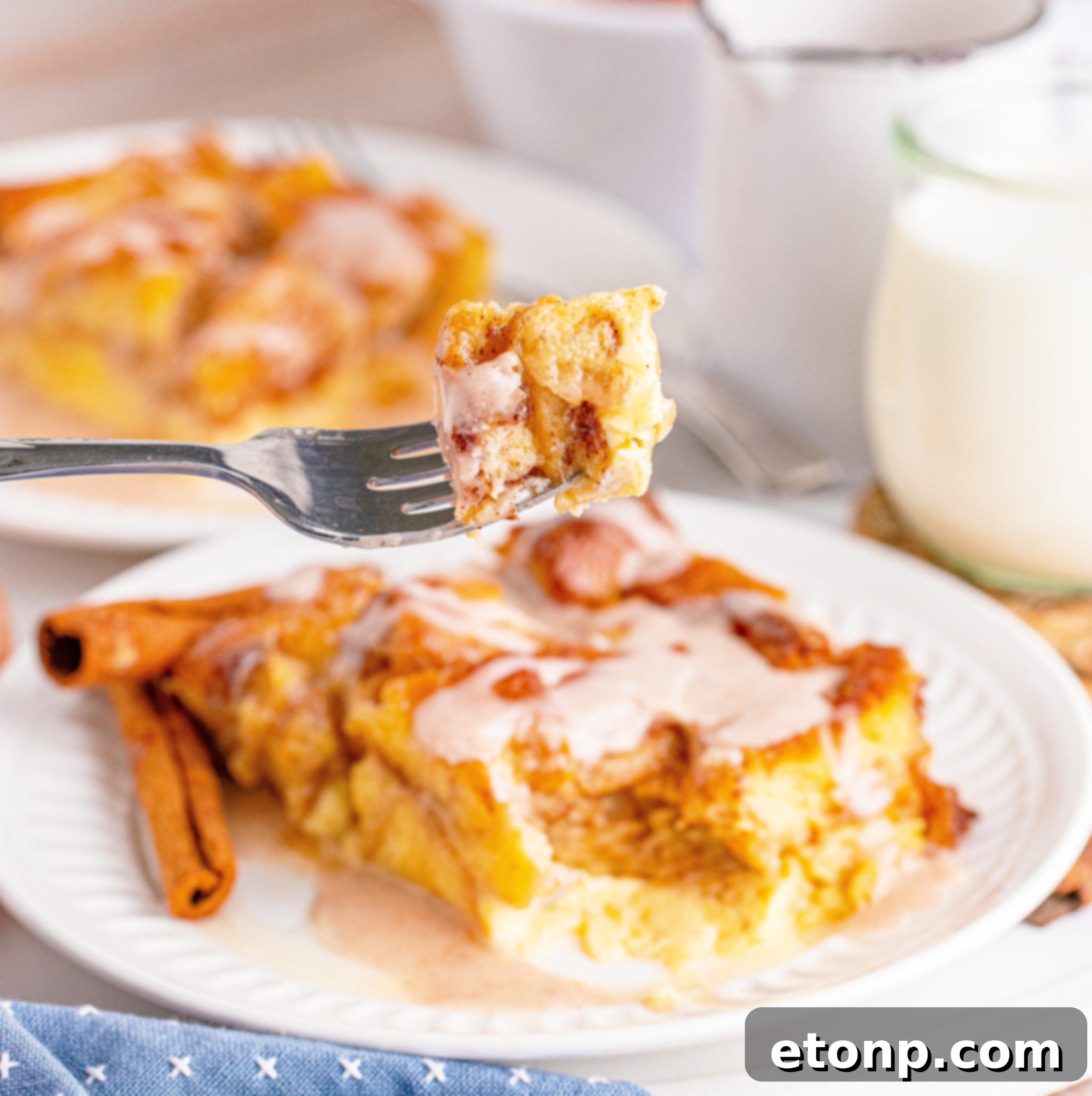 Serving of Glazed Honeybun Bread Pudding on a plate with a fork
