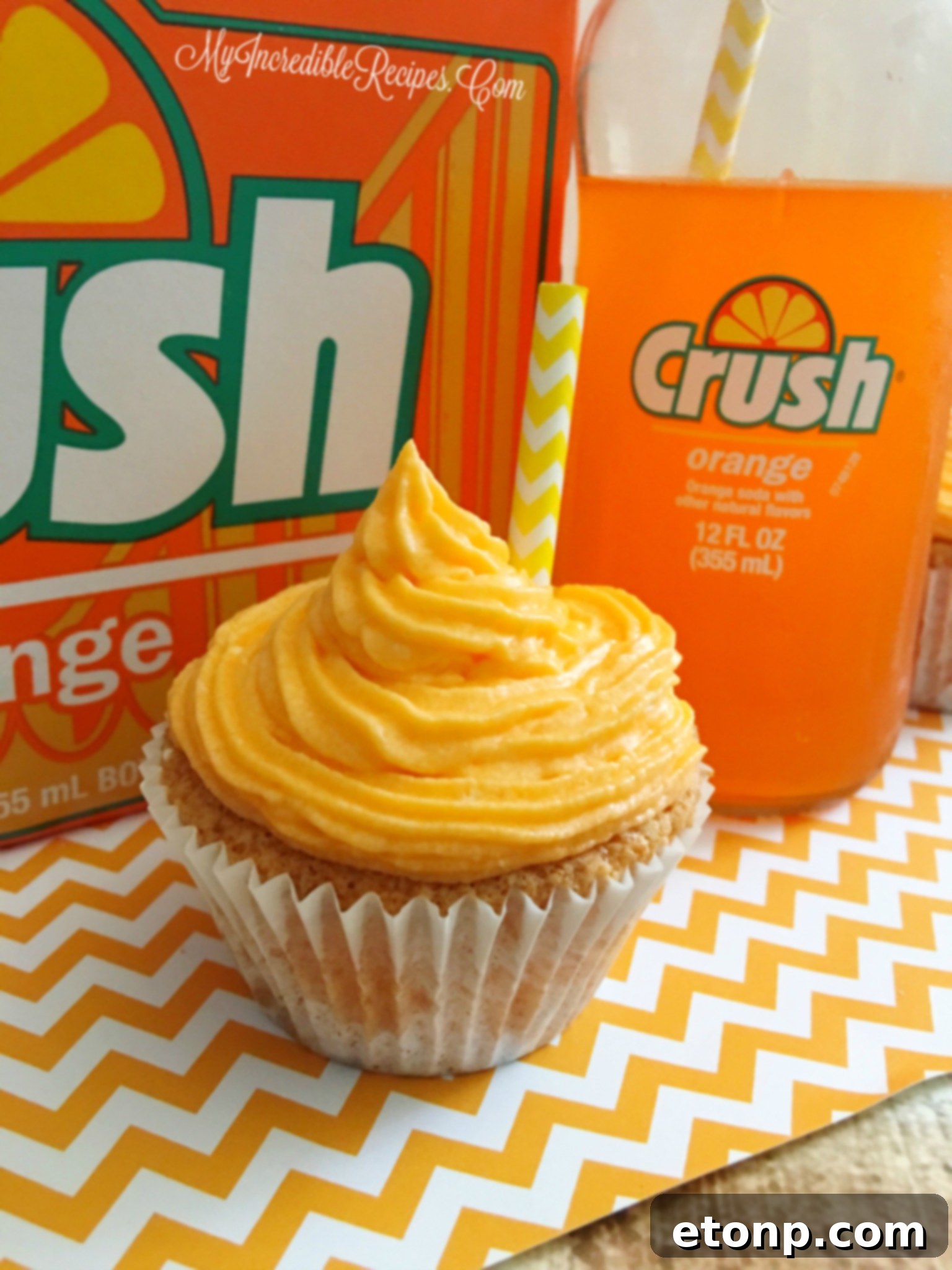 An Orange Creamsicle Cupcake cut in half, revealing a creamy white filling in its center