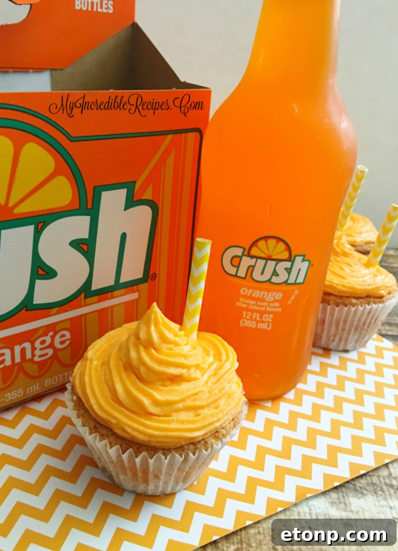 Close-up shot of an Orange Creamsicle Cupcake, highlighting the texture of the orange and white swirl frosting
