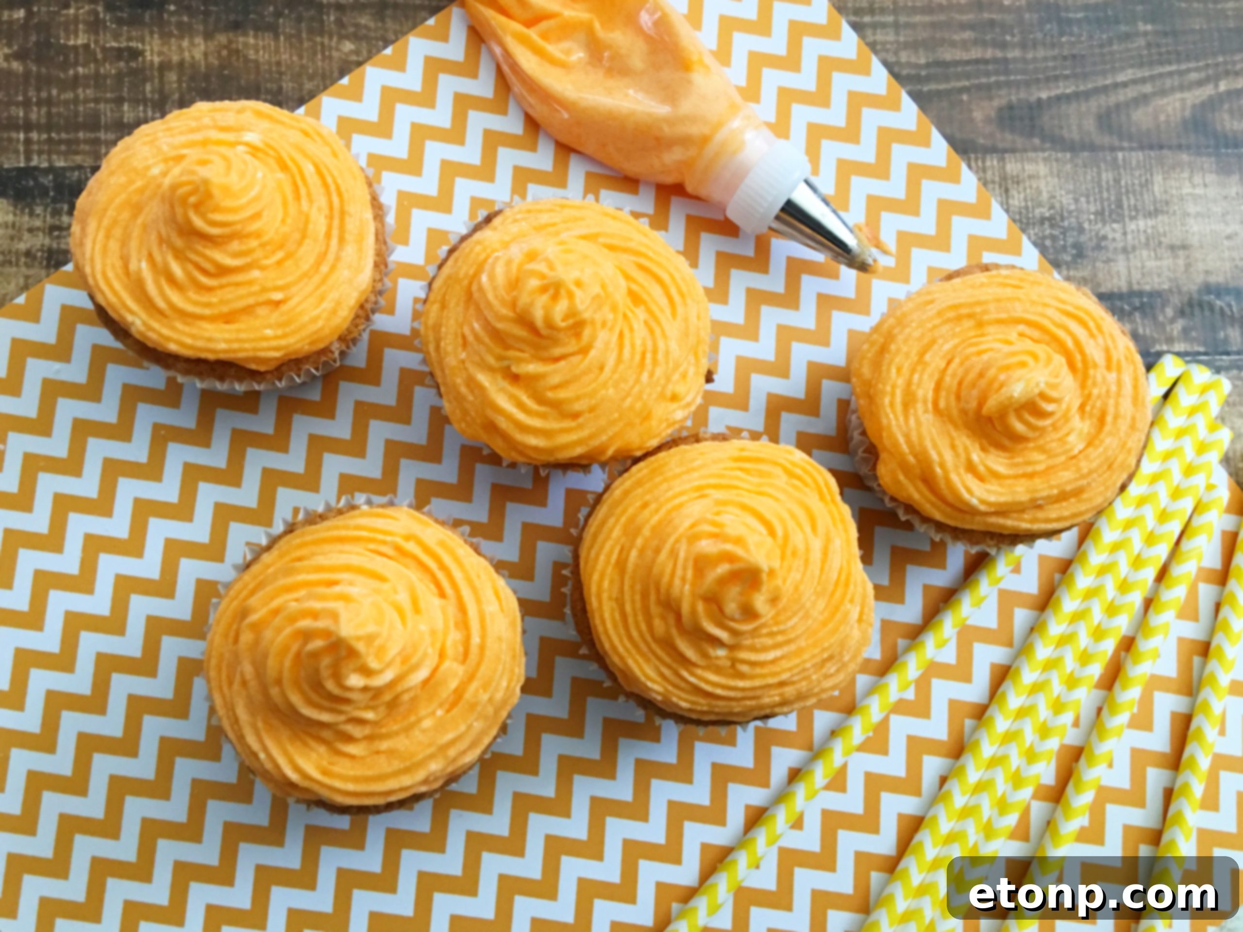 A collection of freshly baked and frosted Orange Creamsicle Cupcakes displayed on a stylish tray