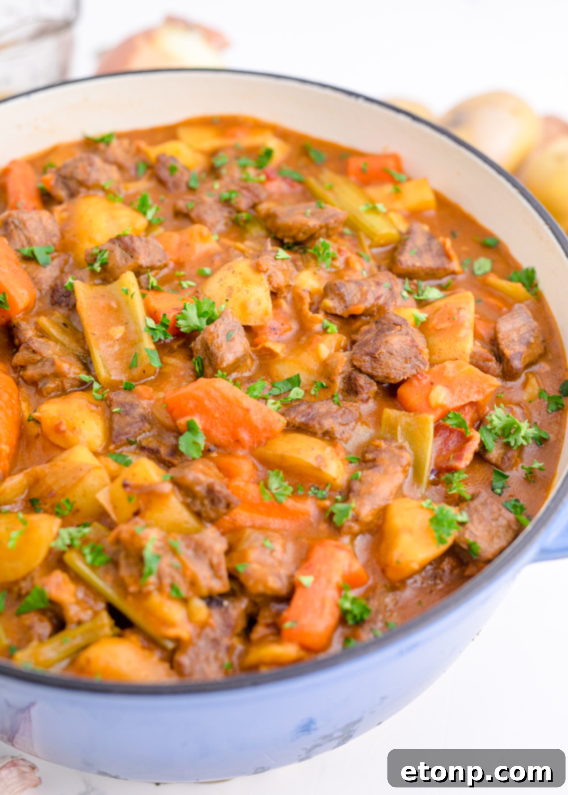 A close-up shot of the Guinness Beef Stew simmering in a Dutch oven, showing the textures of the beef and vegetables.
