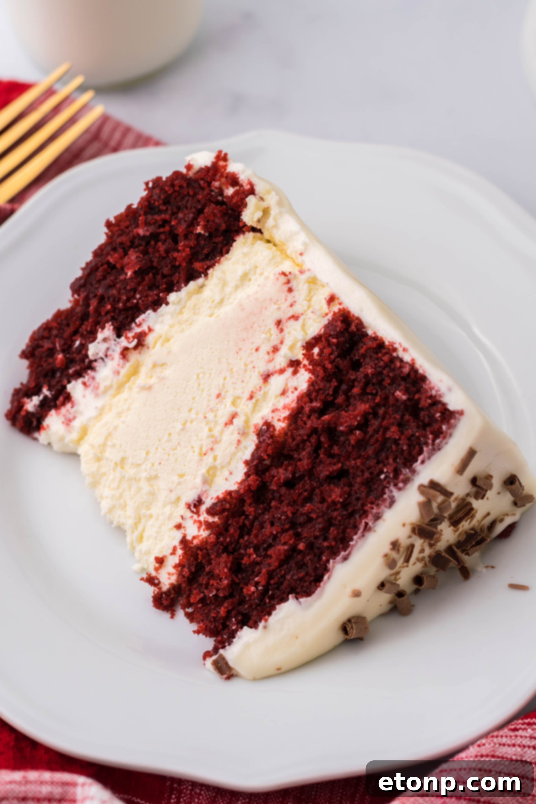 A beautifully frosted Red Velvet Cheesecake Cake, adorned with chocolate shavings.