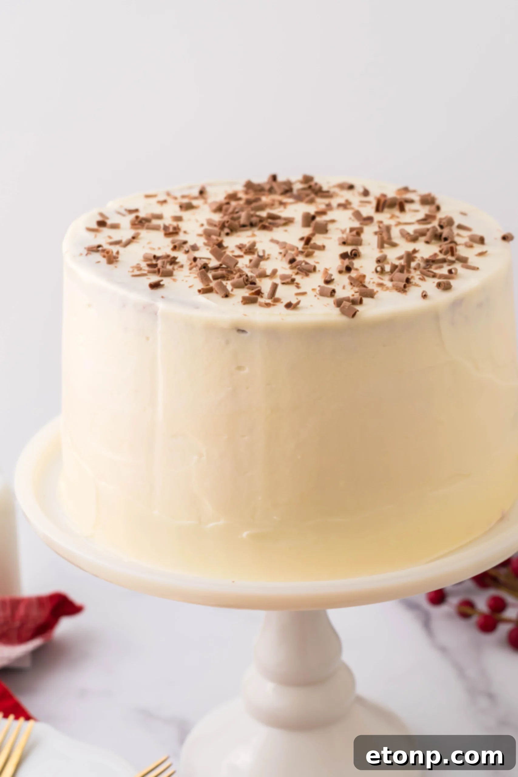 A close-up view of the whole Red Velvet Cheesecake Cake, showcasing the perfectly smooth cream cheese frosting.