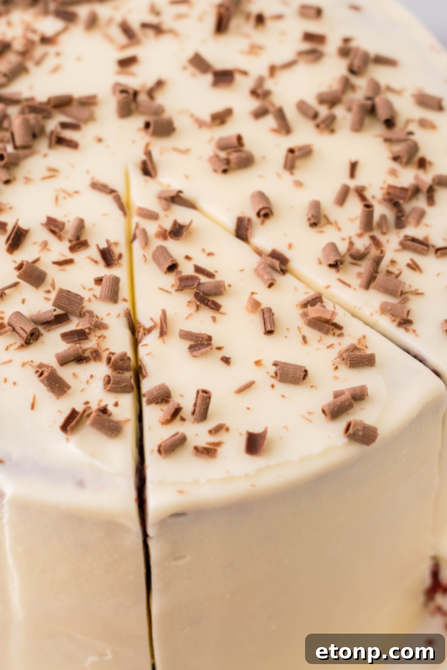 A block of cream cheese, a key ingredient for both the cheesecake and the frosting, sitting on a counter.